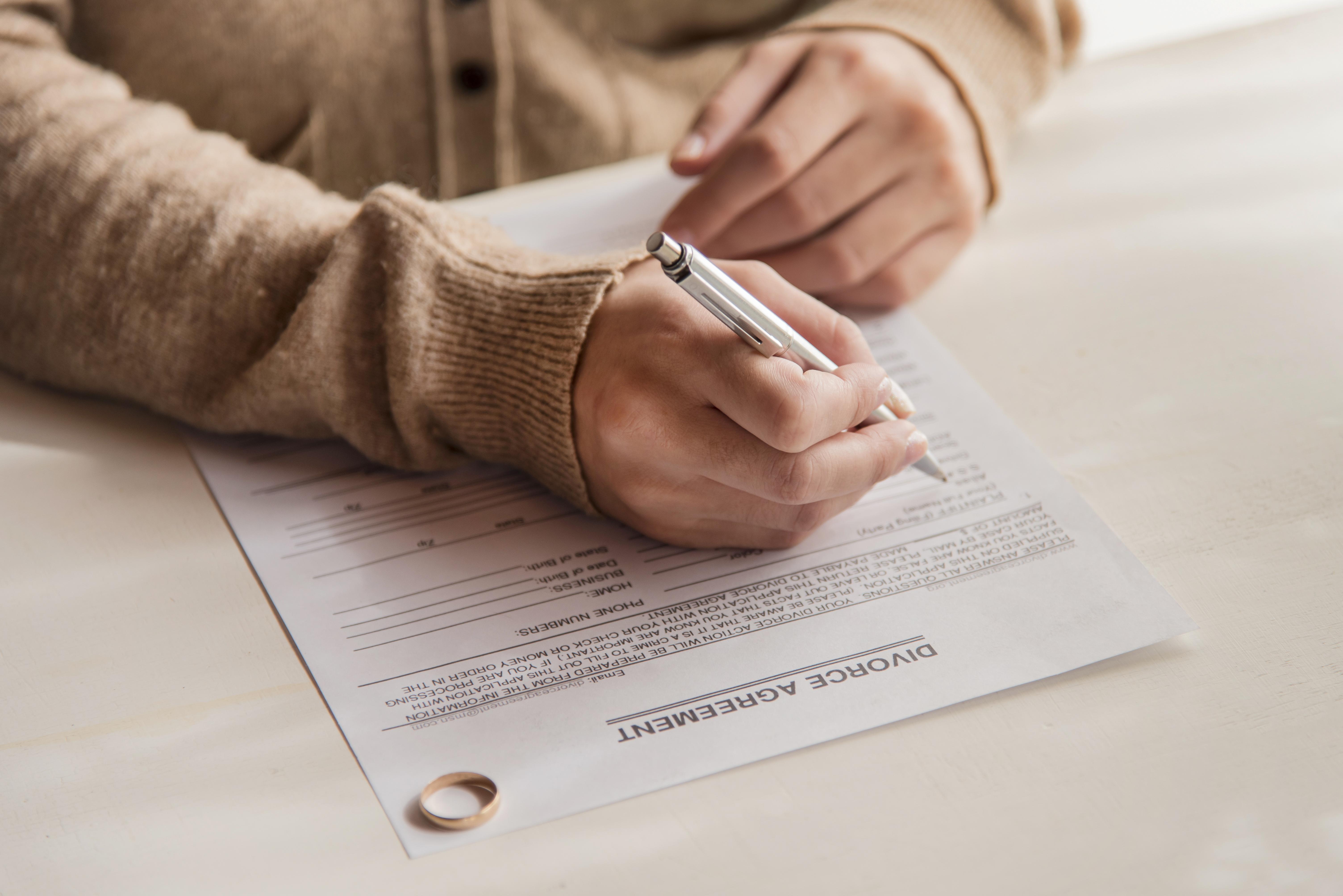 A woman signing divorce agreement | Source: Freepik