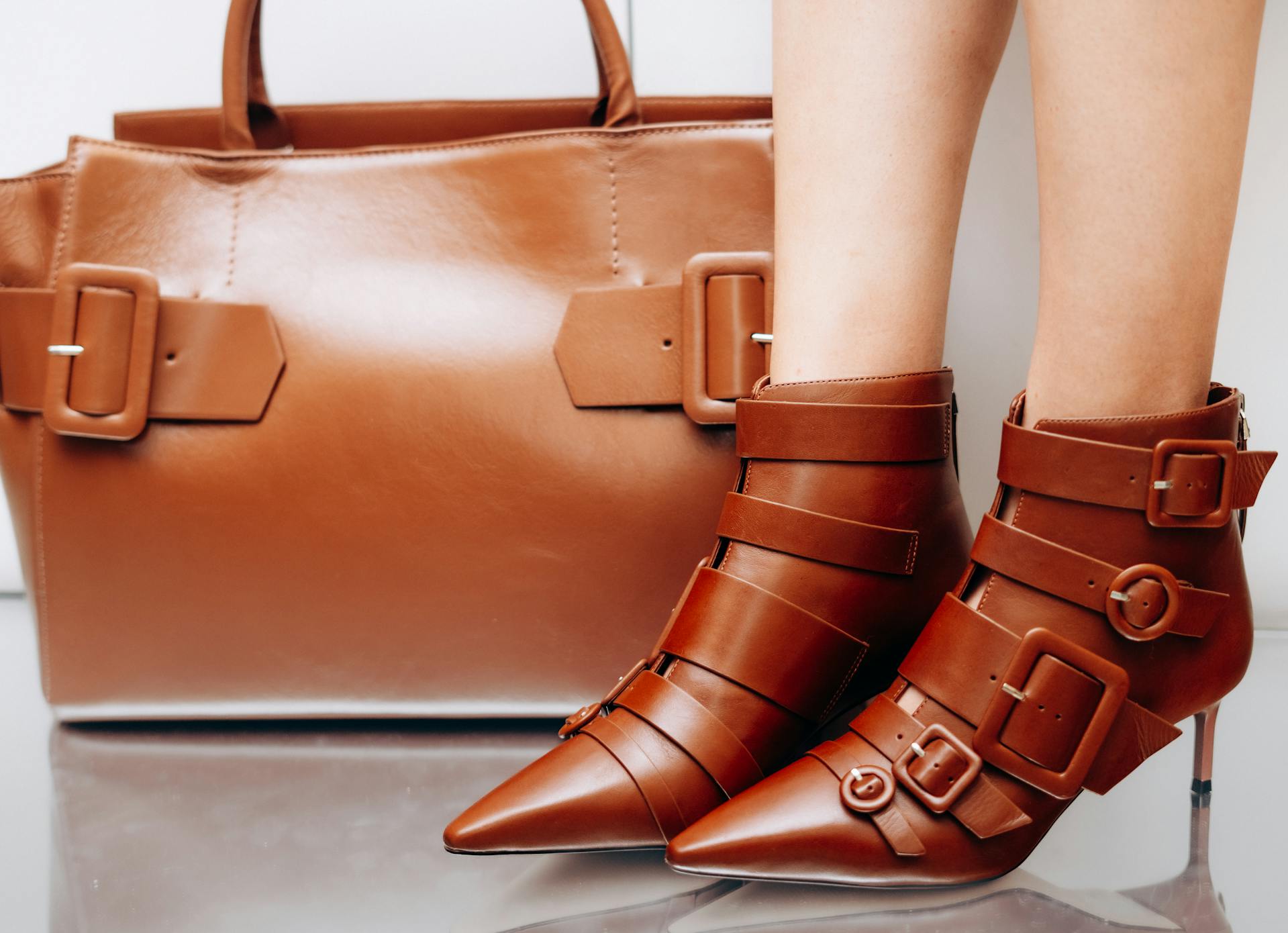 A handbag on the floor near a woman's feet | Source: Pexels