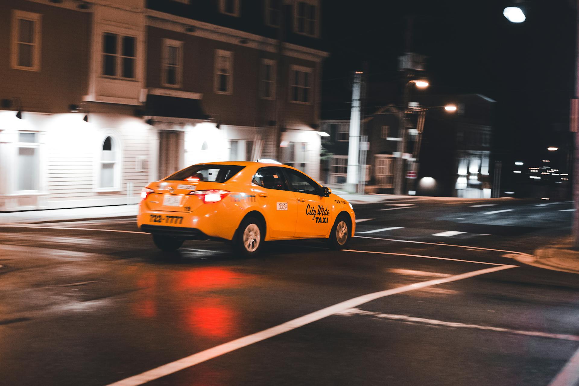 A taxi driving through a city at night | Source: Pexels