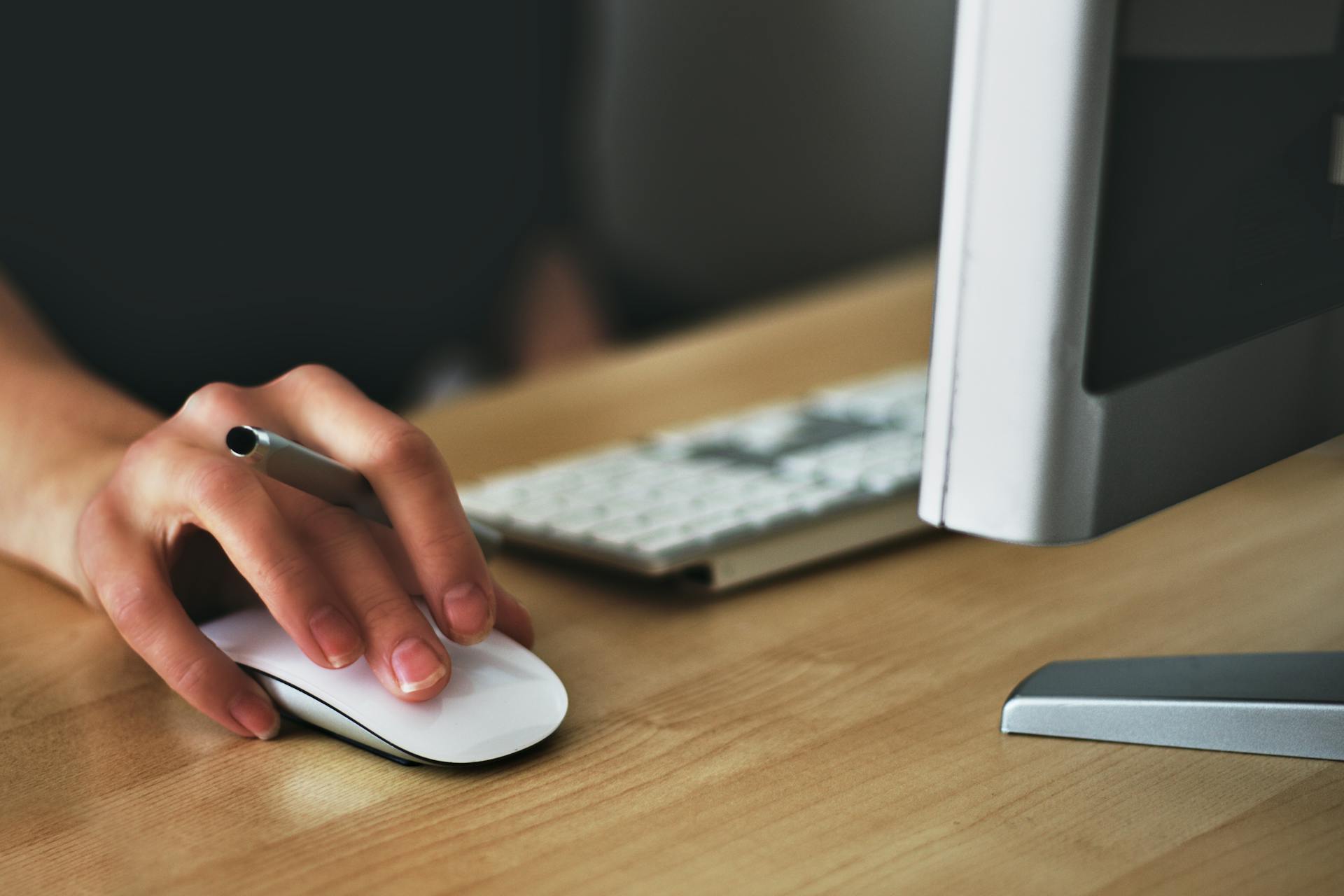 A person holding a pen and a mouse | Source: Pexels