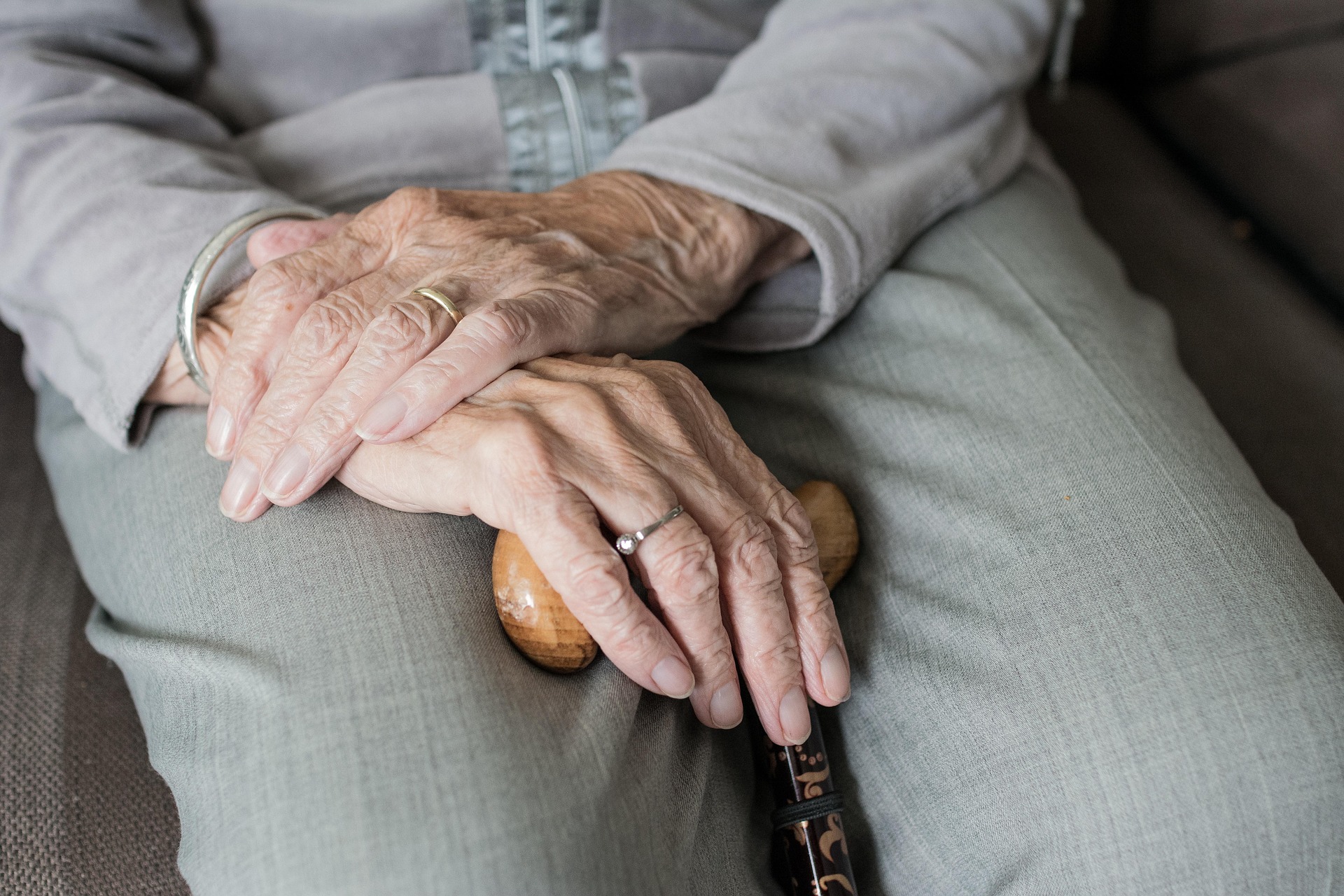 Cropped shot of an older woman sitting while holding her cane | Source: Pixabay