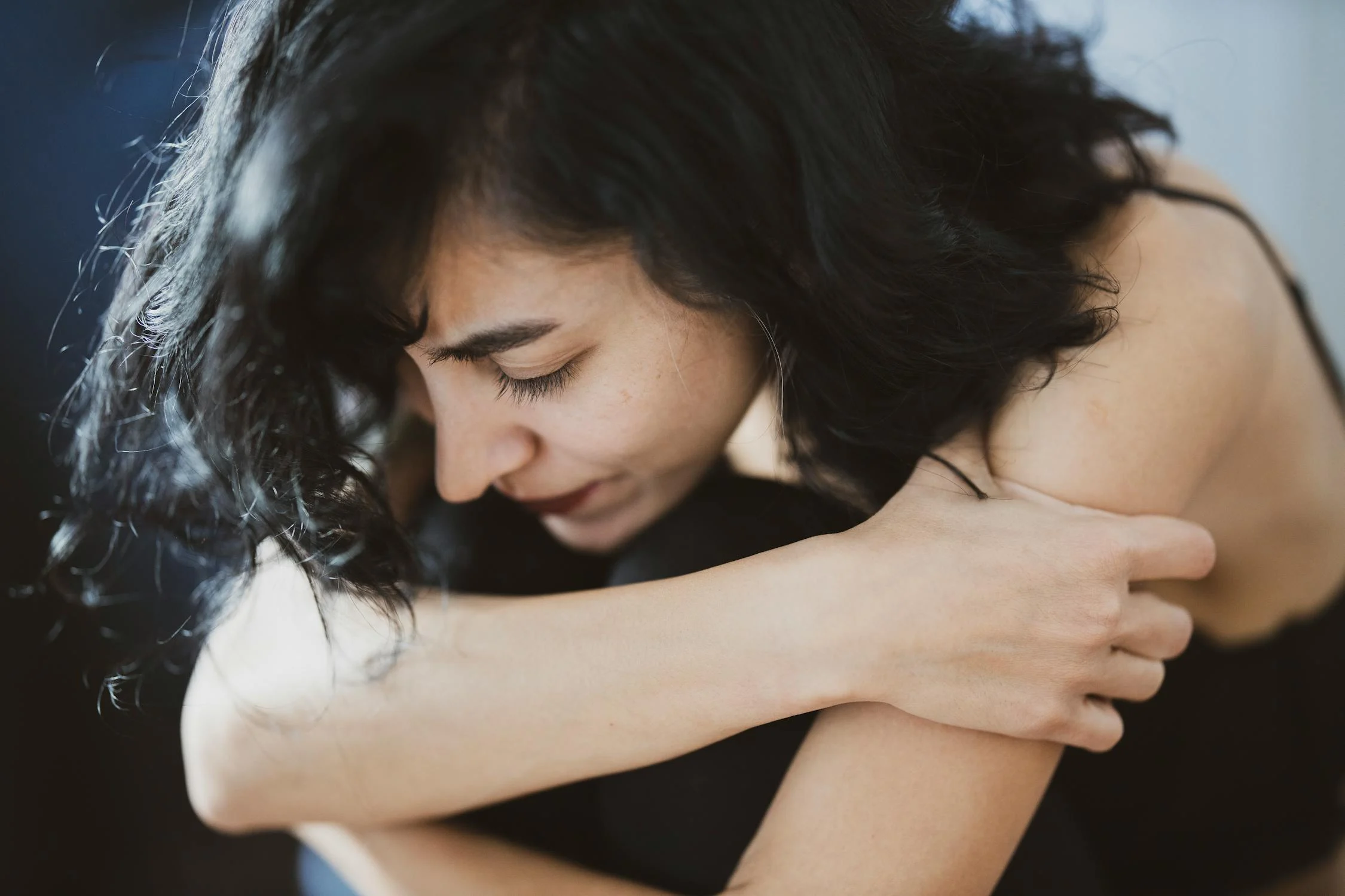 A sad woman hugging her knees | Source: Pexels