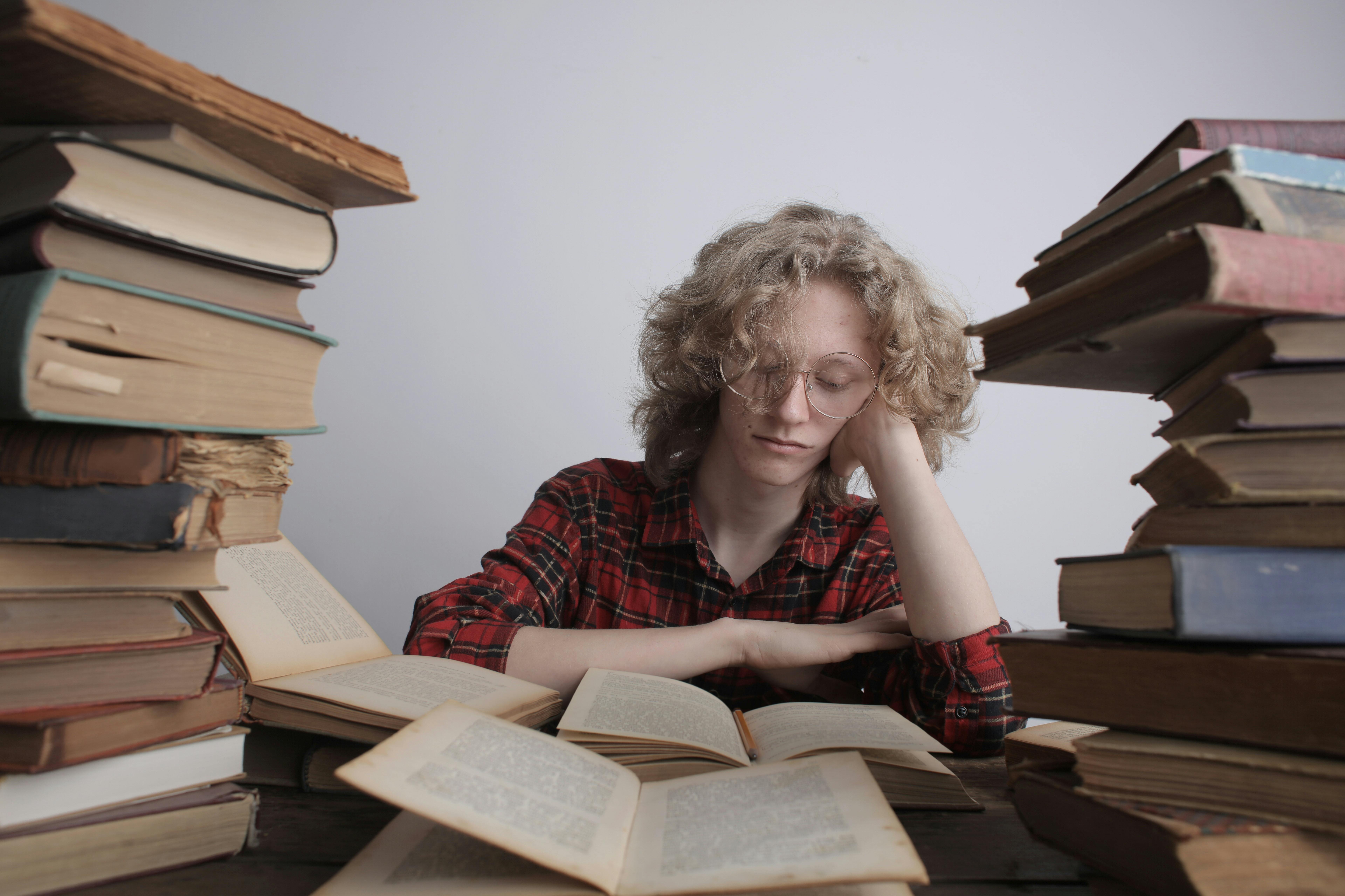 Um cara na faculdade estudando | Fonte: Pexels