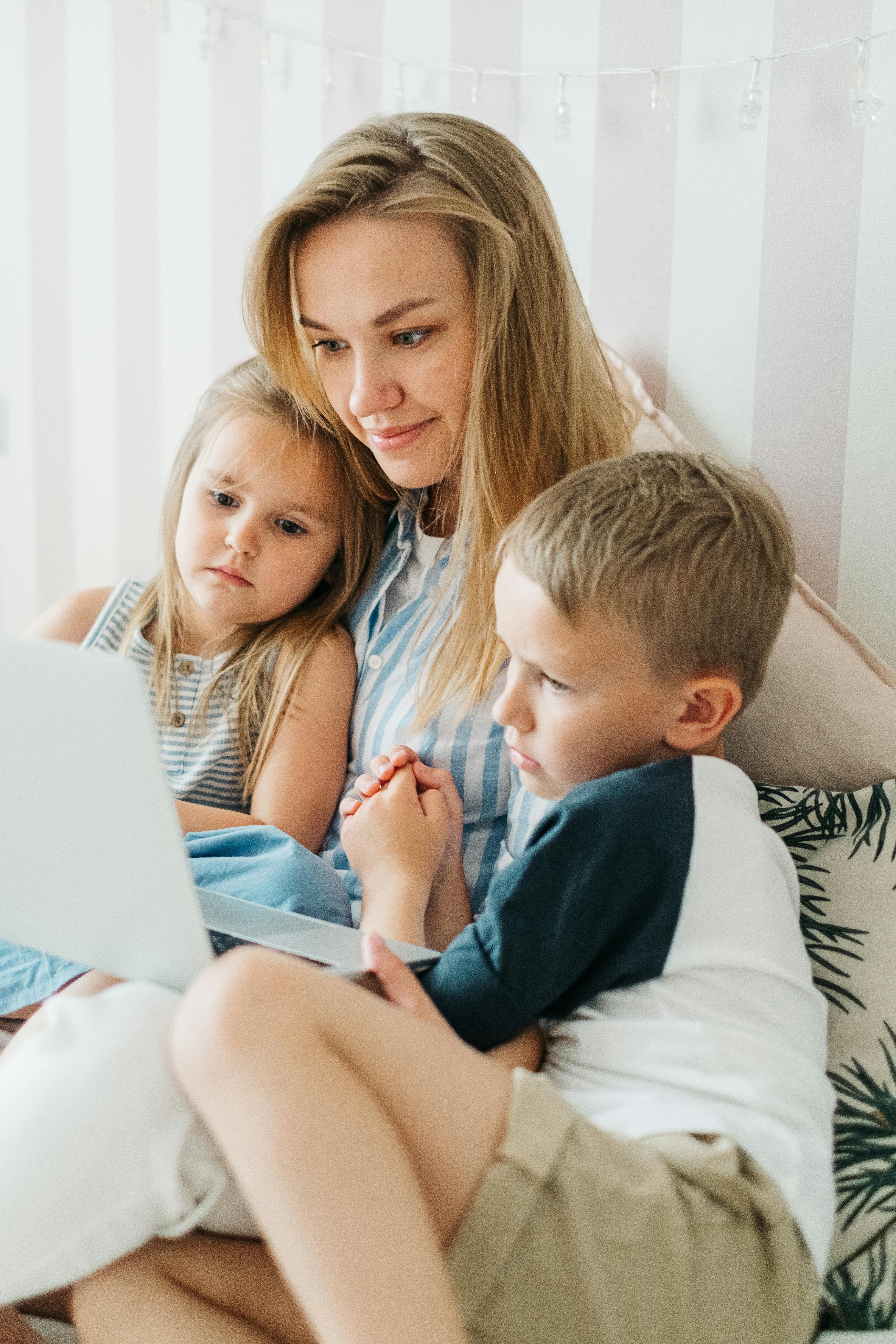 A woman and her children using a laptop | Source: Pexels