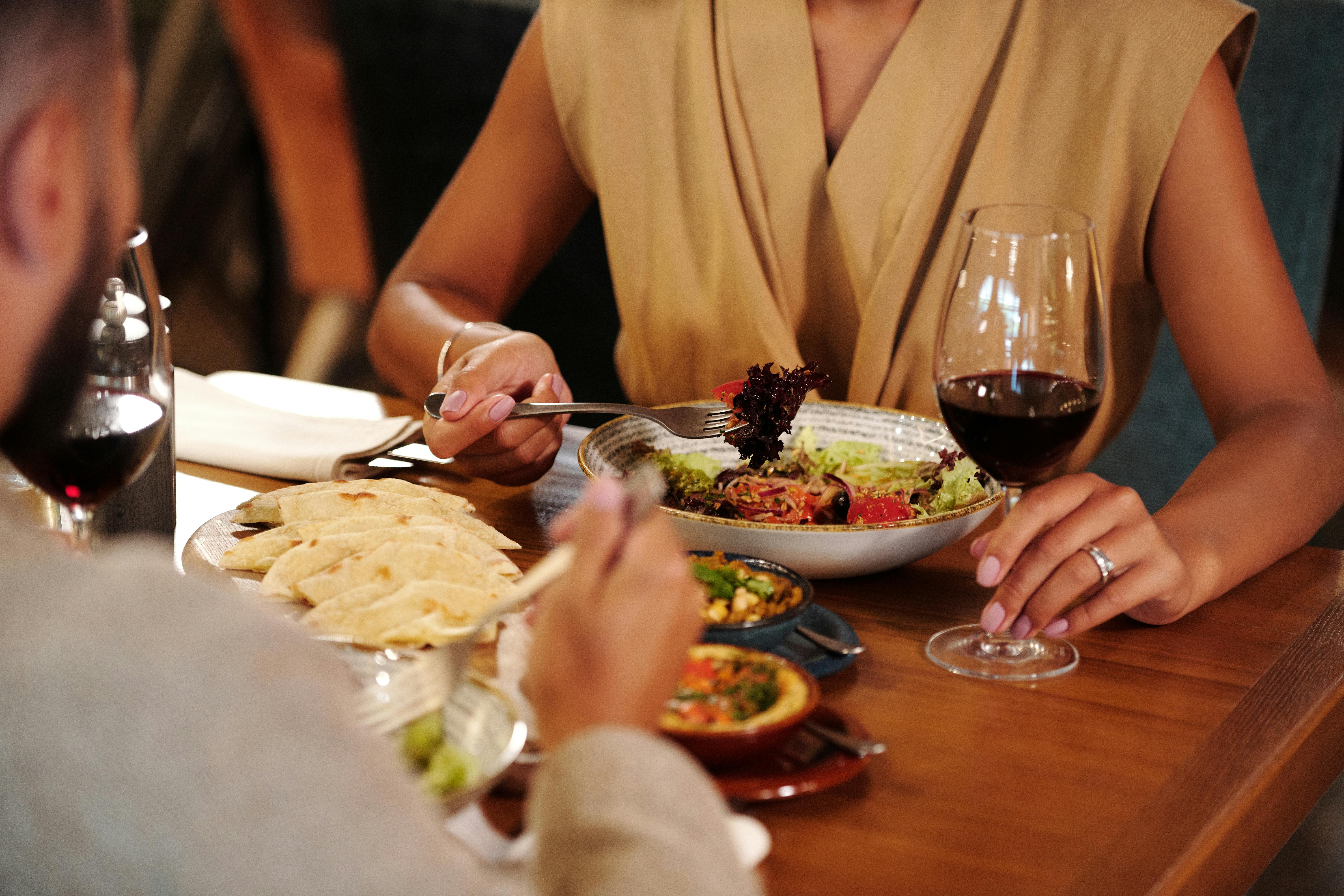 Woman, wearing engagement ring, at dinner with her fiancé | Source: Pexels