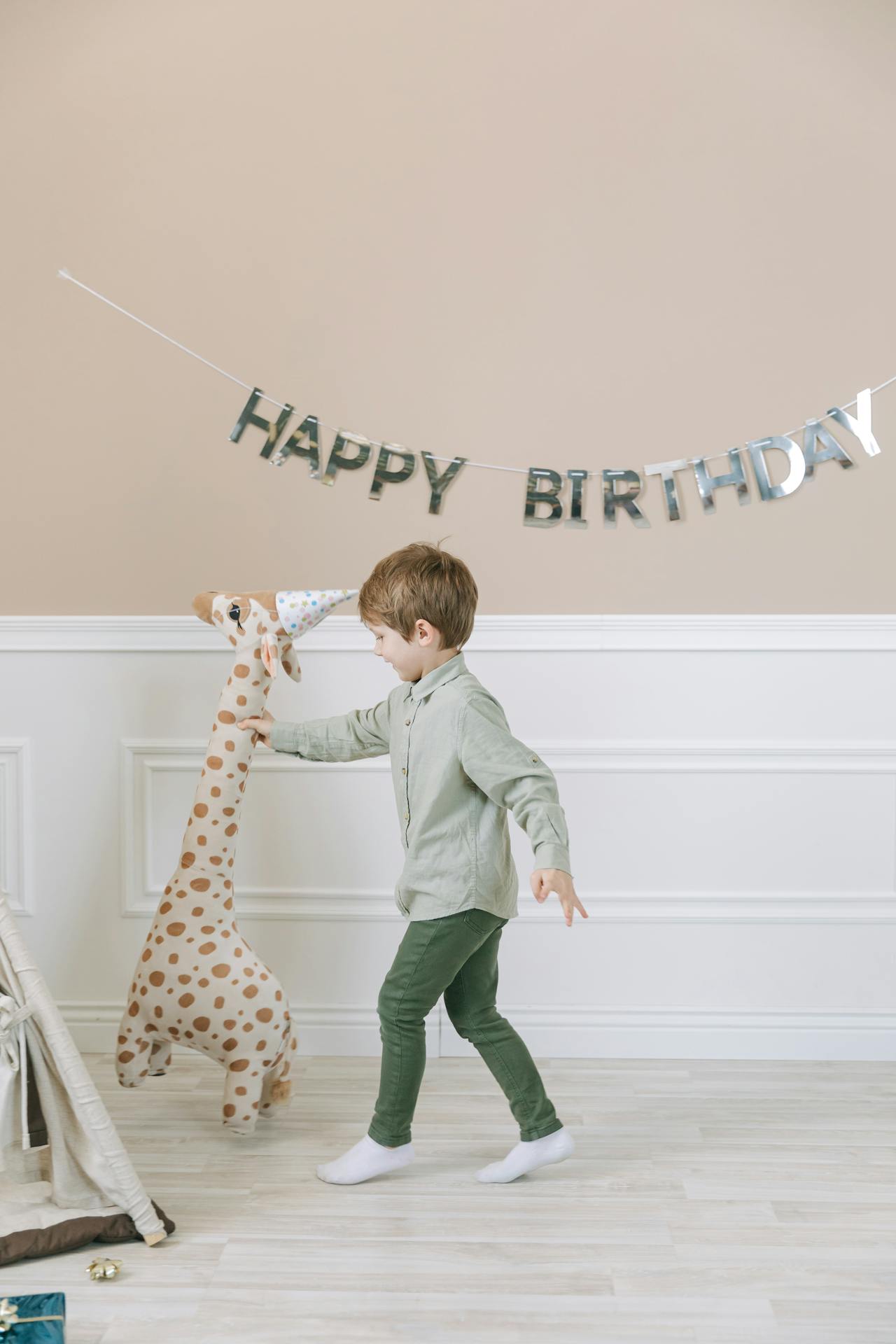 A delighted little boy holding a giraffe plushie | Source: Pexels