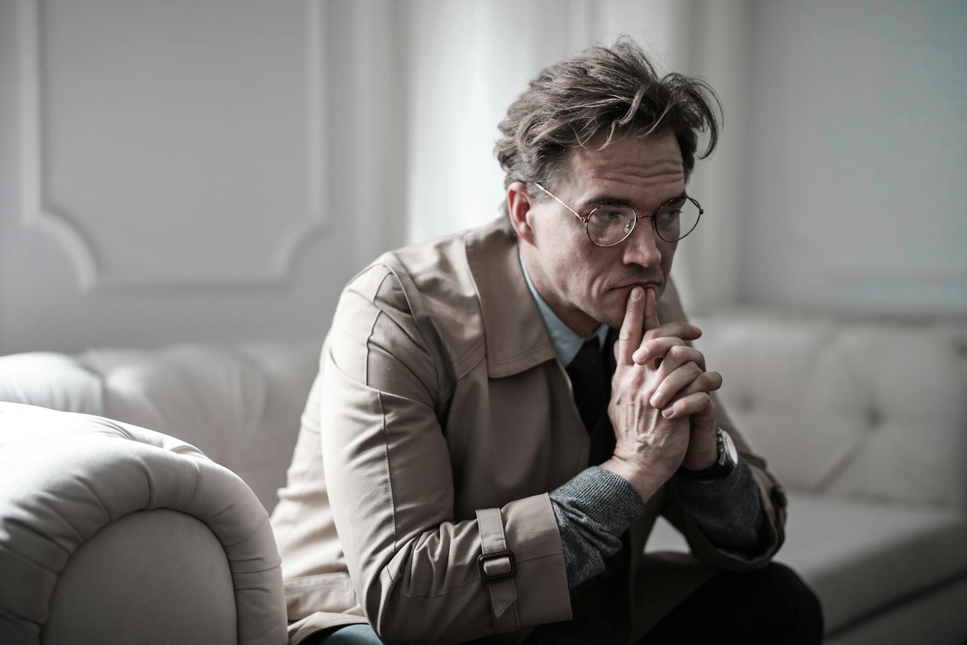 A thoughtful man sitting on a sofa | Source: Pexels