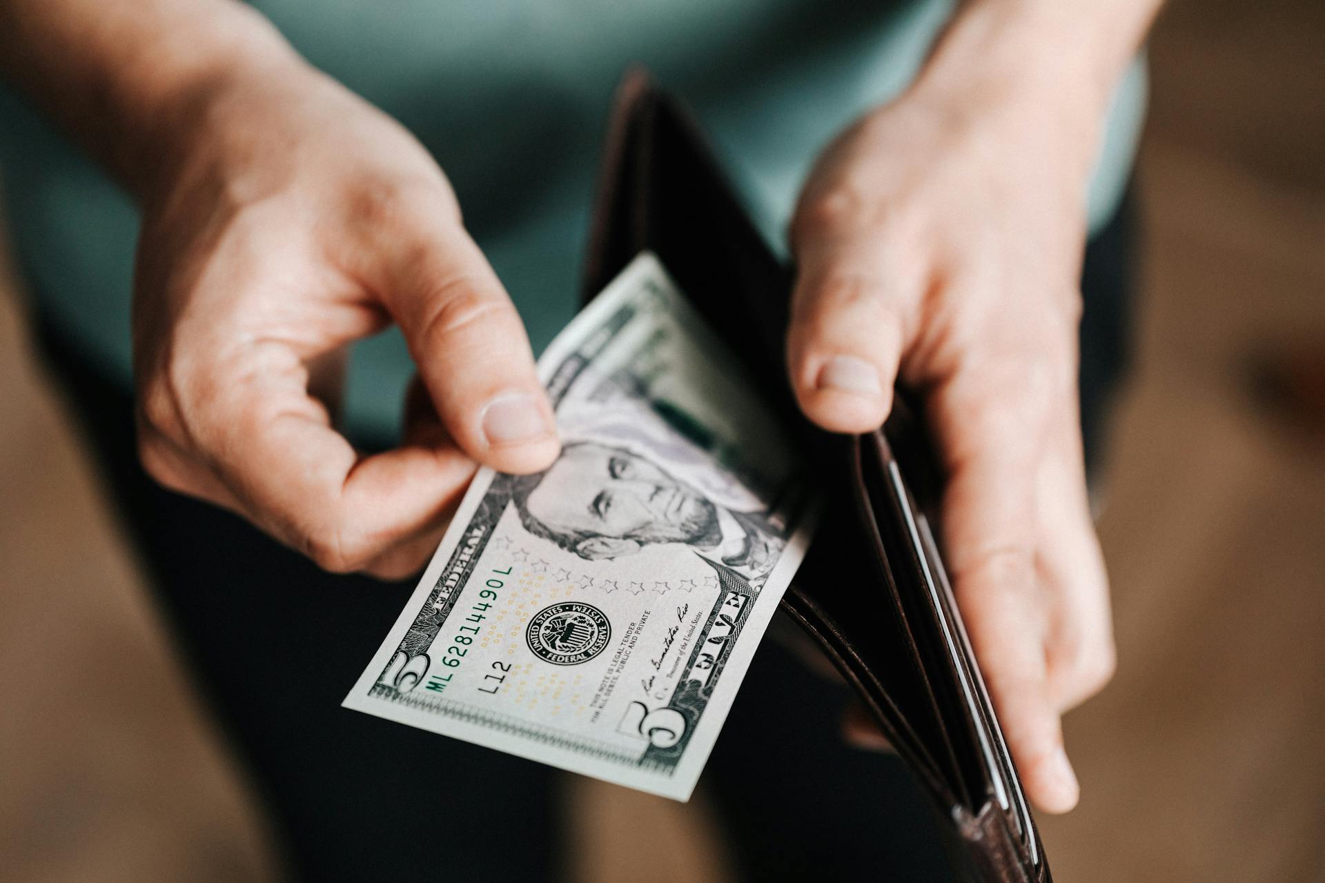 A man taking out money from a wallet | Source: Pexels