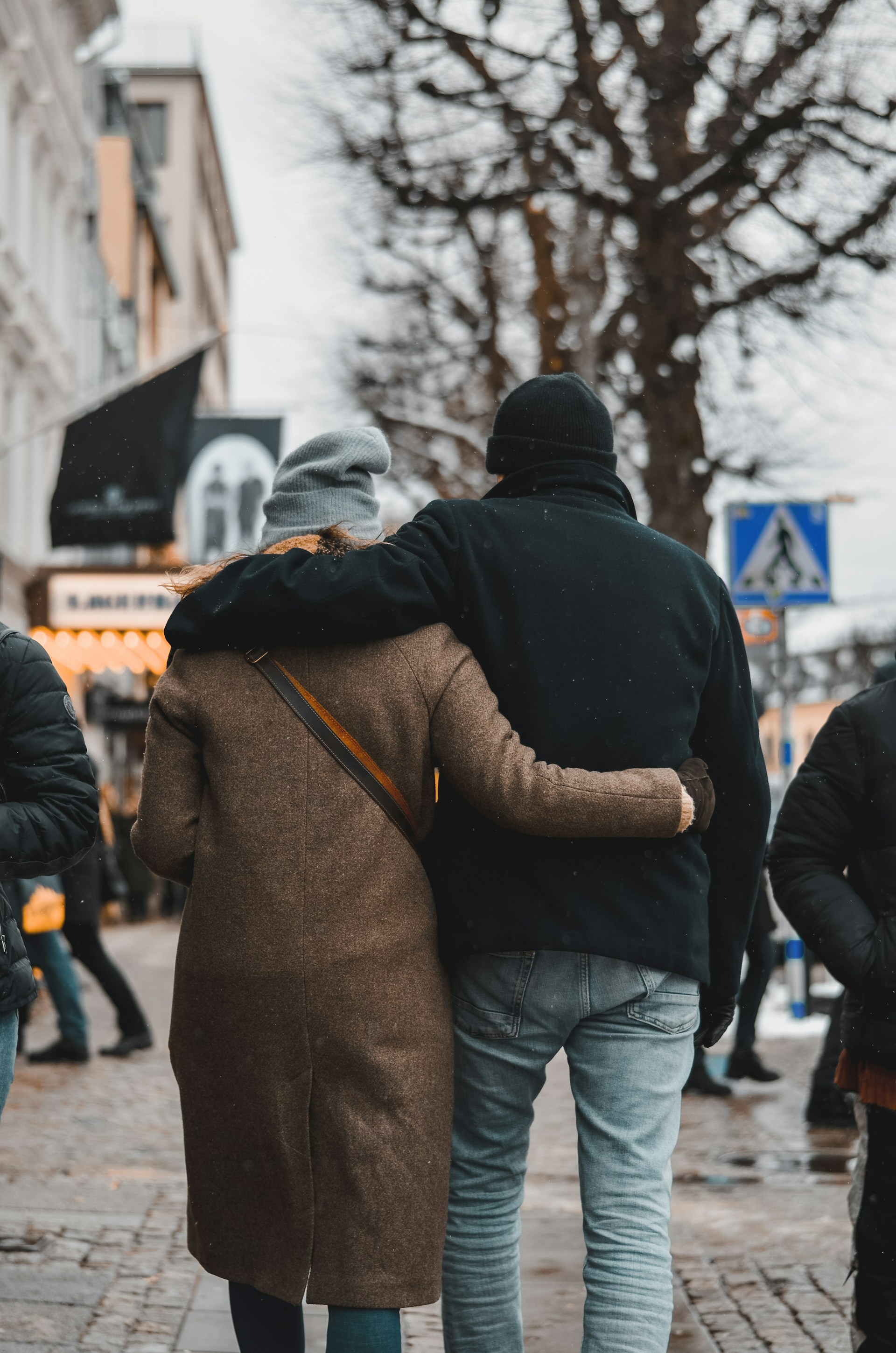 A couple embracing each other and walking on the street | Source: Unsplash