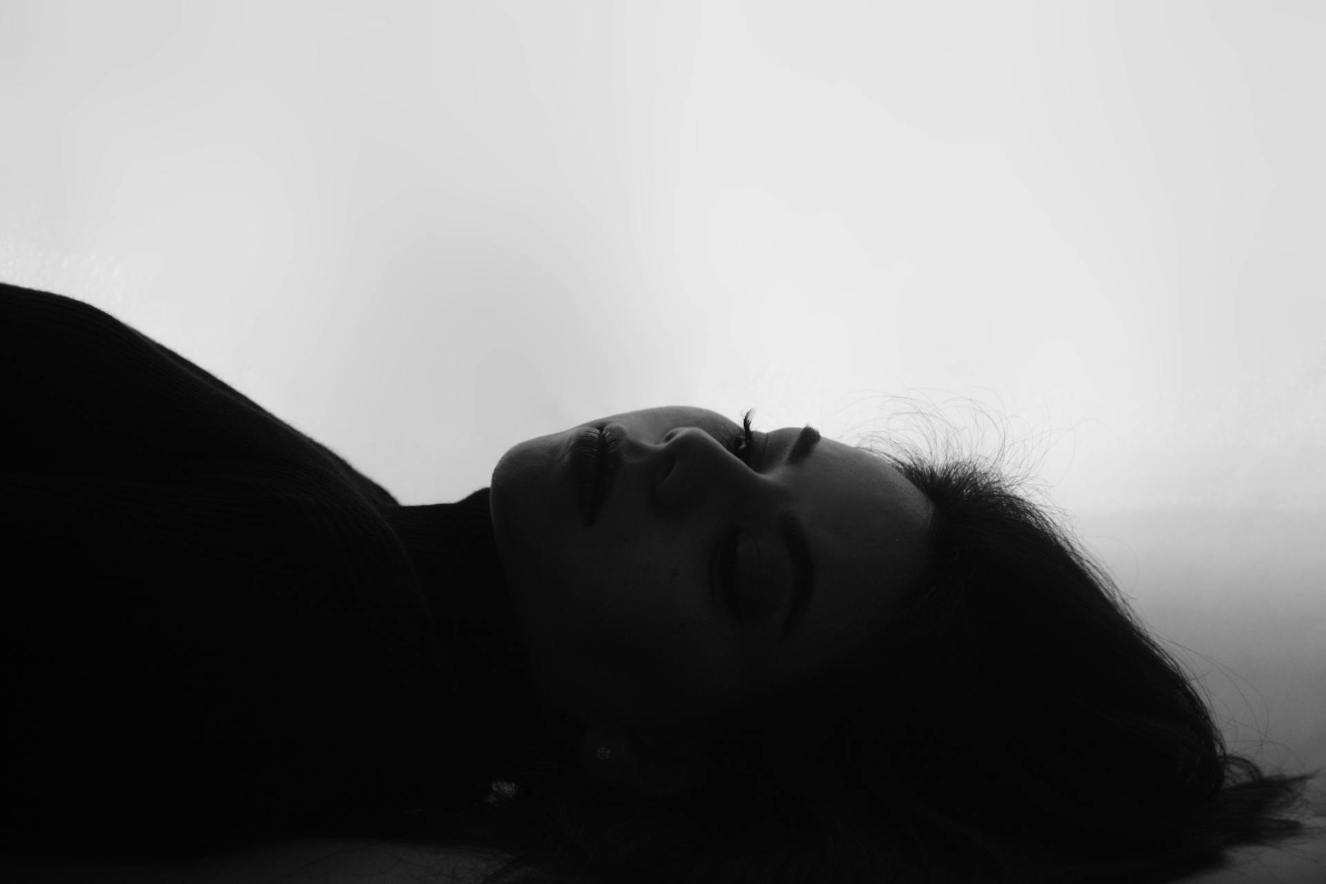 Grayscale shot of a woman lying down | Source: Pexels