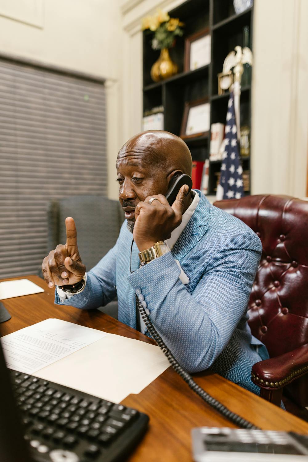 A man talking on his phone in his office | Source: Pexels