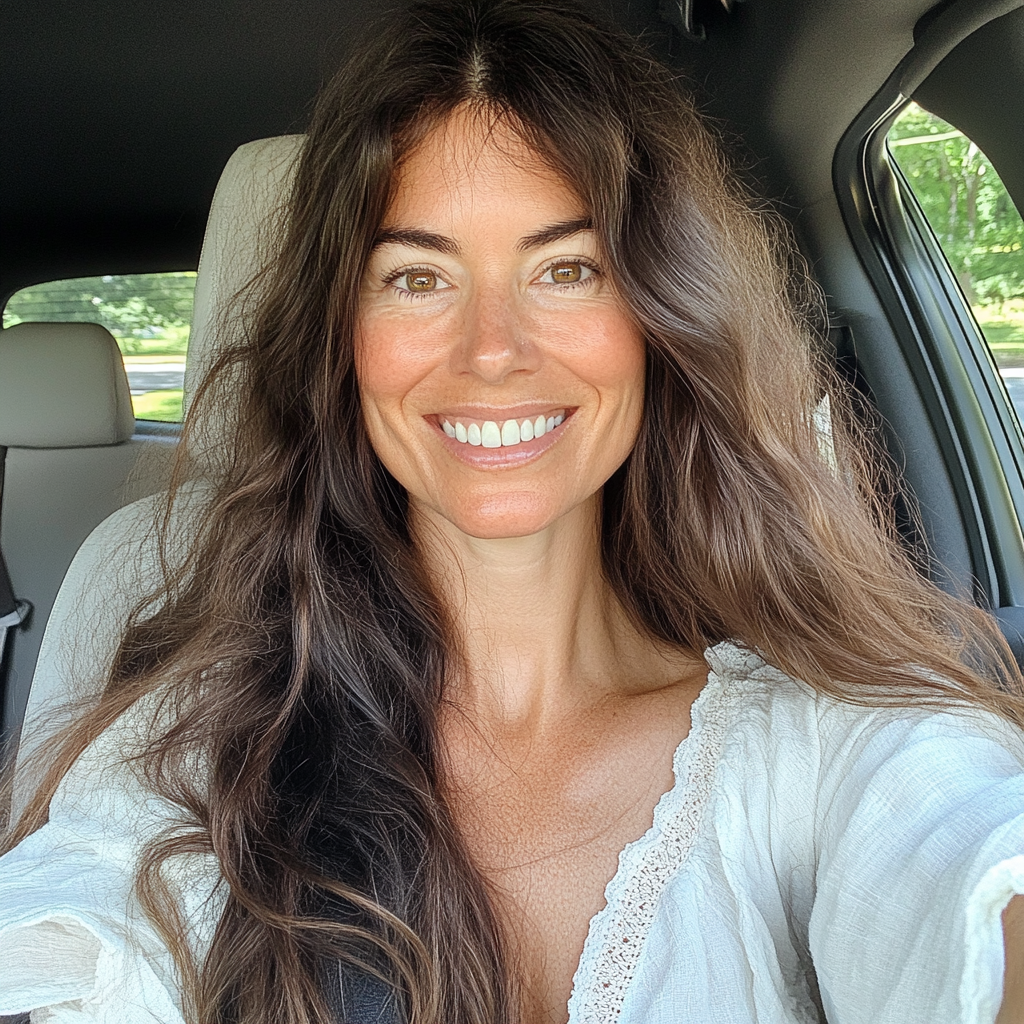 A smiling woman sitting in a car | Source: Midjourney