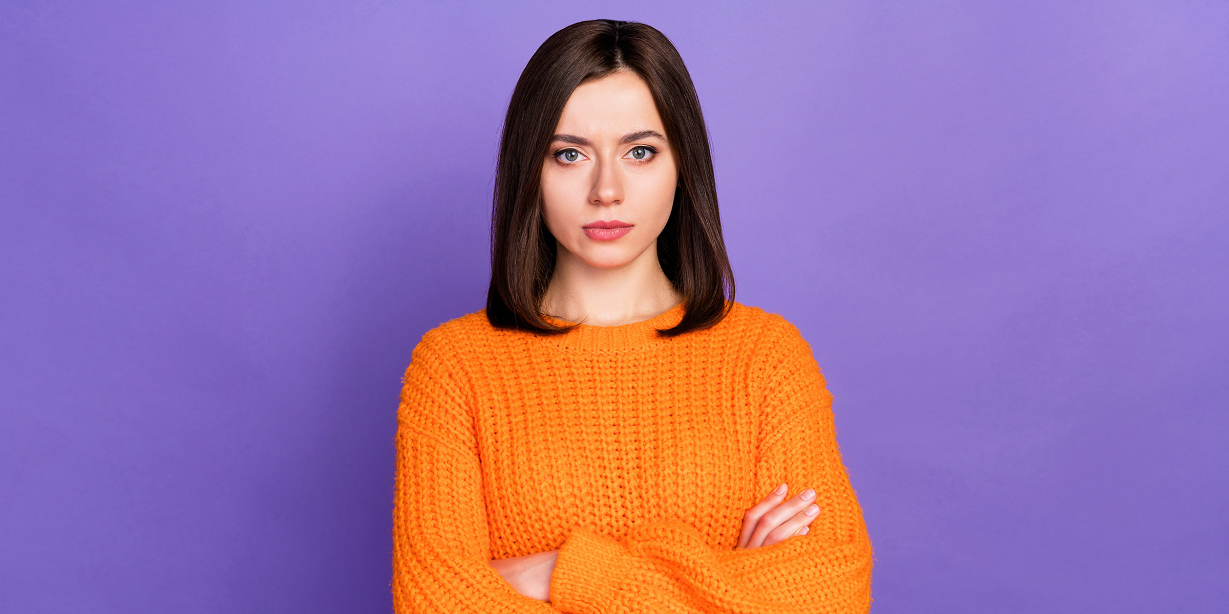 A woman standing with her arms crossed | Source: Shutterstock