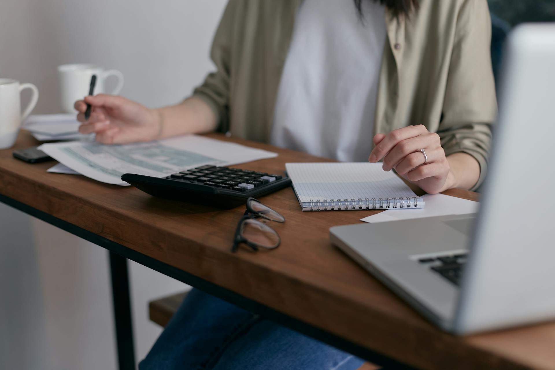 A woman working with a notepad and calculator | Source: Pexels