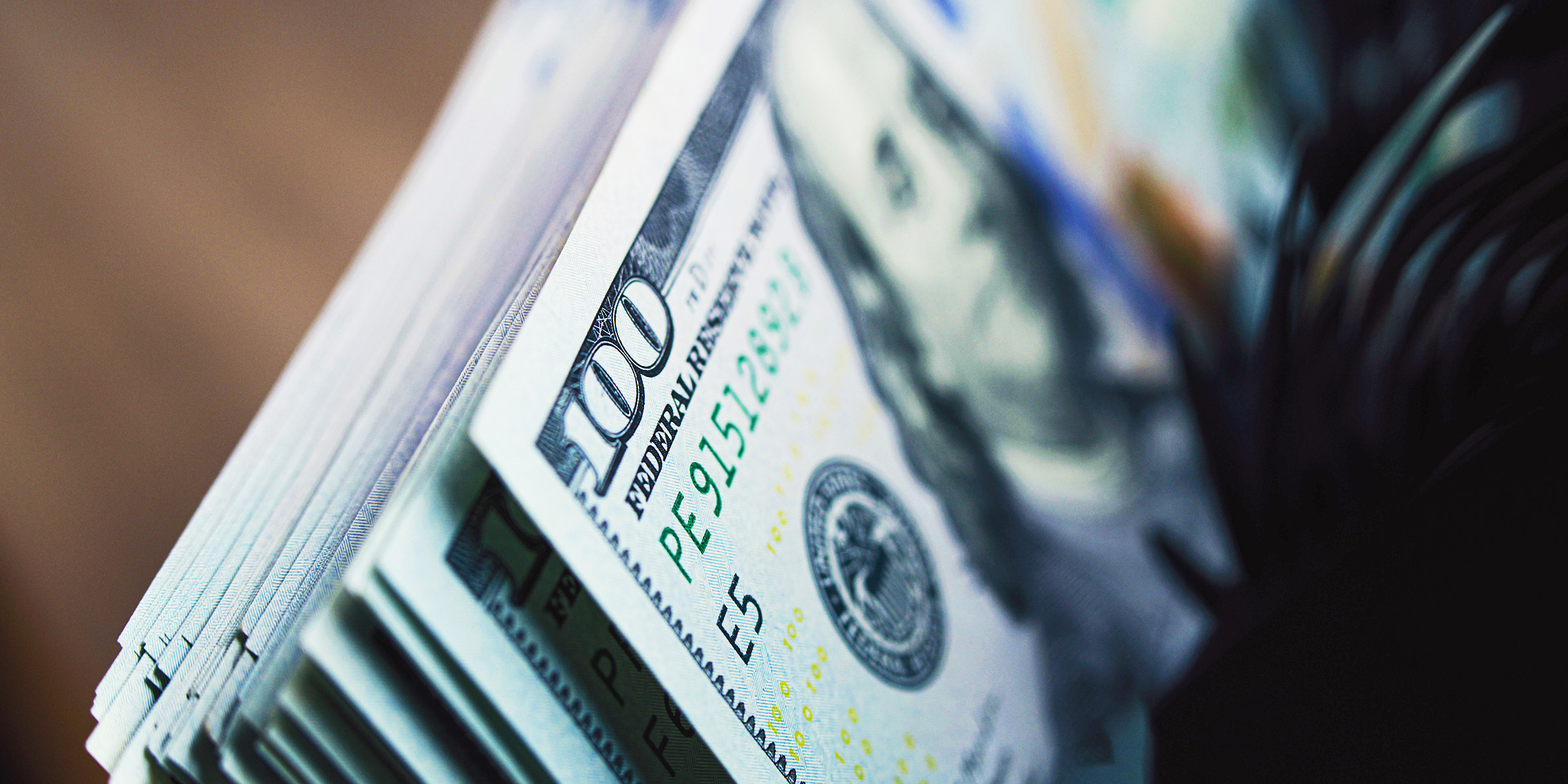 Stack of crisp $100 bills | Source: Shutterstock