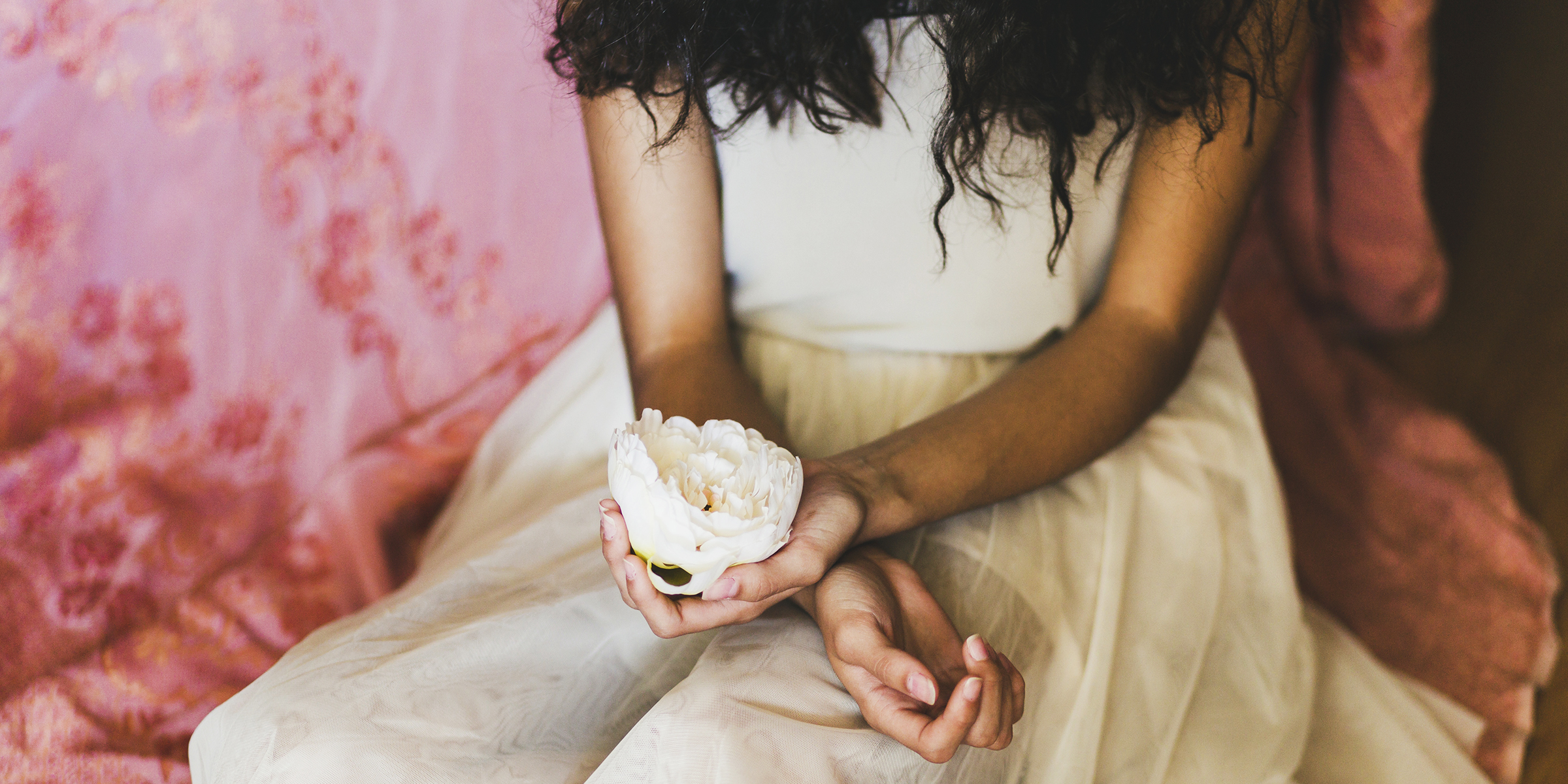 Cropped shot of a woman holding a flower | Source: Freepik