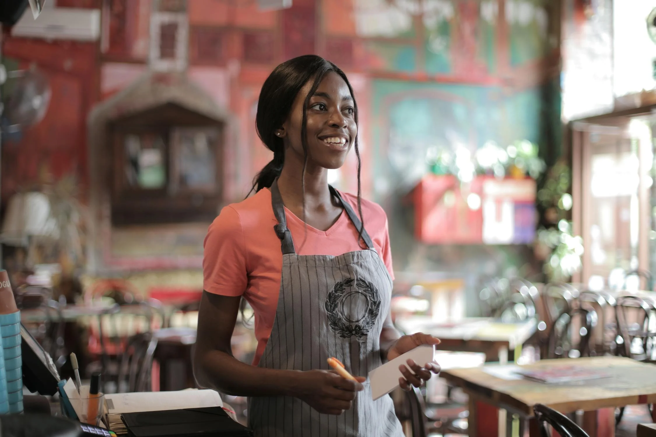 A smiling waitress in a pub | Source: Pexels