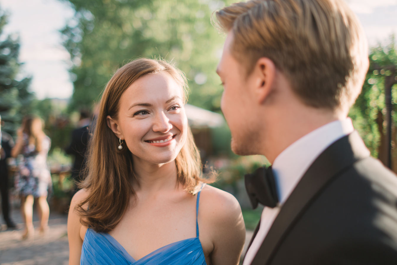 A woman smiling at a man in a suit | Source: Midjourney