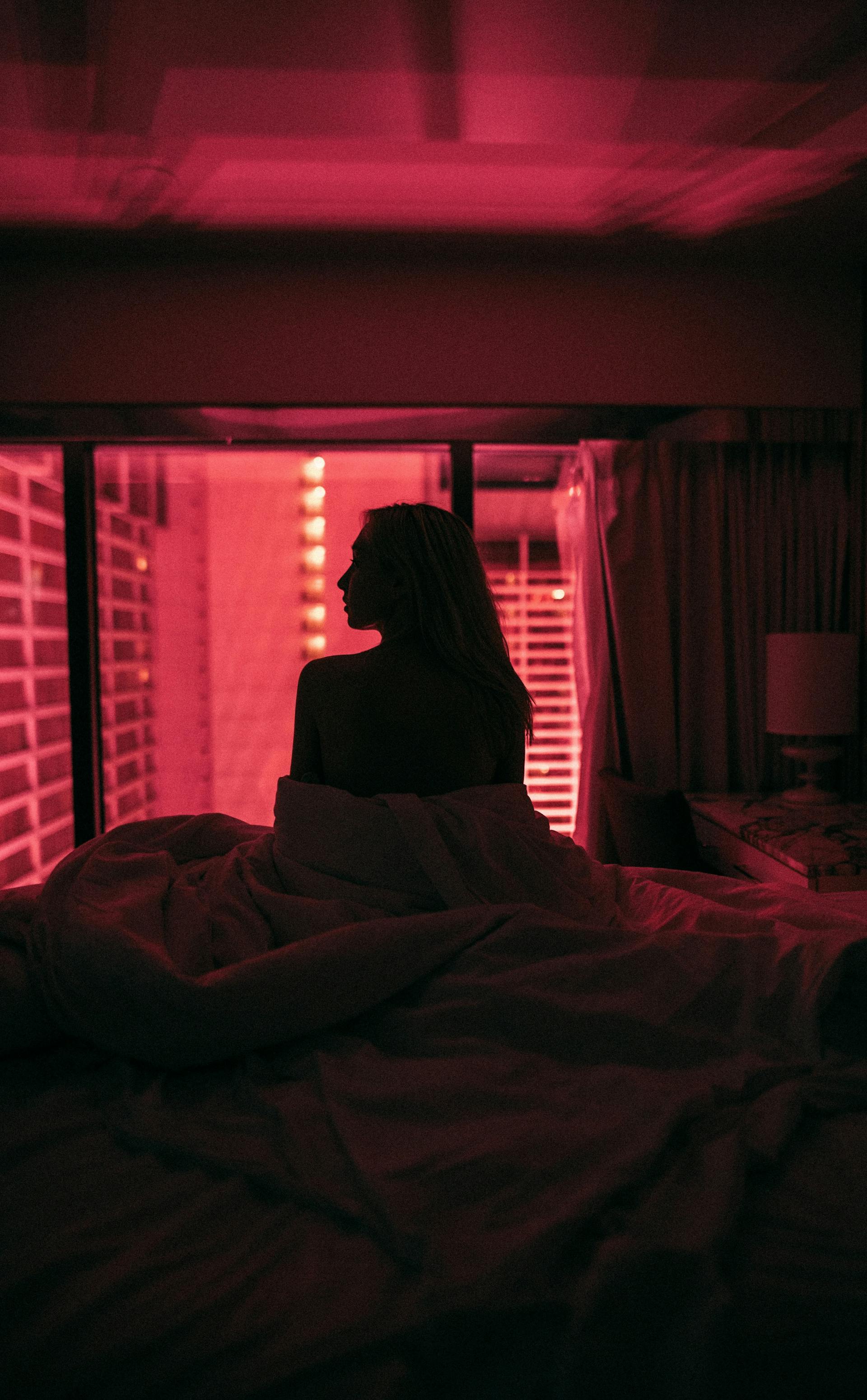 A woman sitting up in bed at night | Source: Pexels