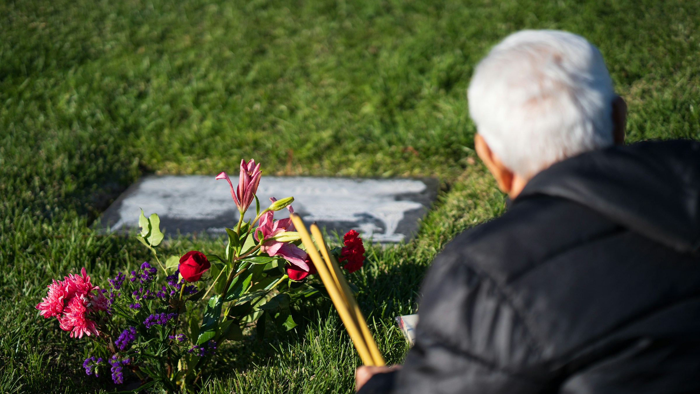 A back-view shot of an old man visiting a loved one's grave | Source: Unsplash