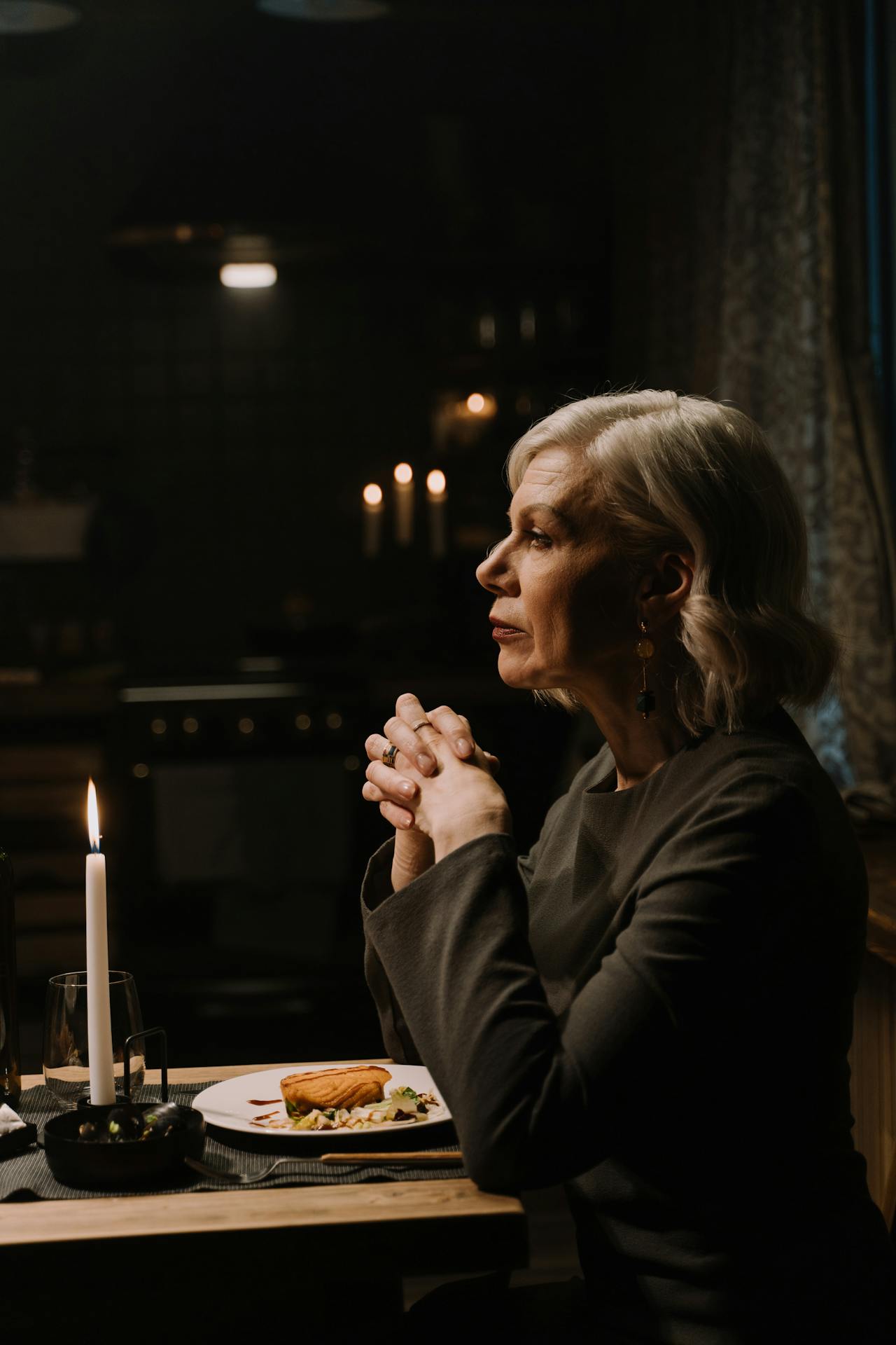 An elegant older woman seated at a dining table | Source: Pexels
