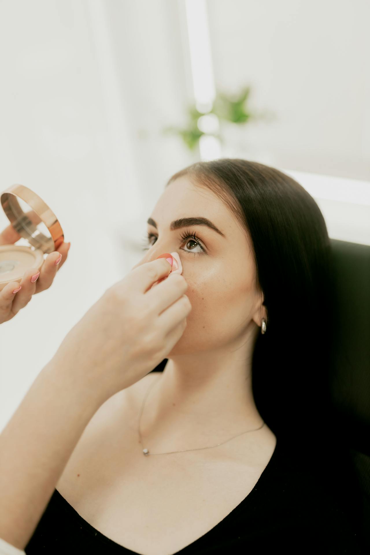 A woman adding touch up to a young lady's face | Source: Pexels