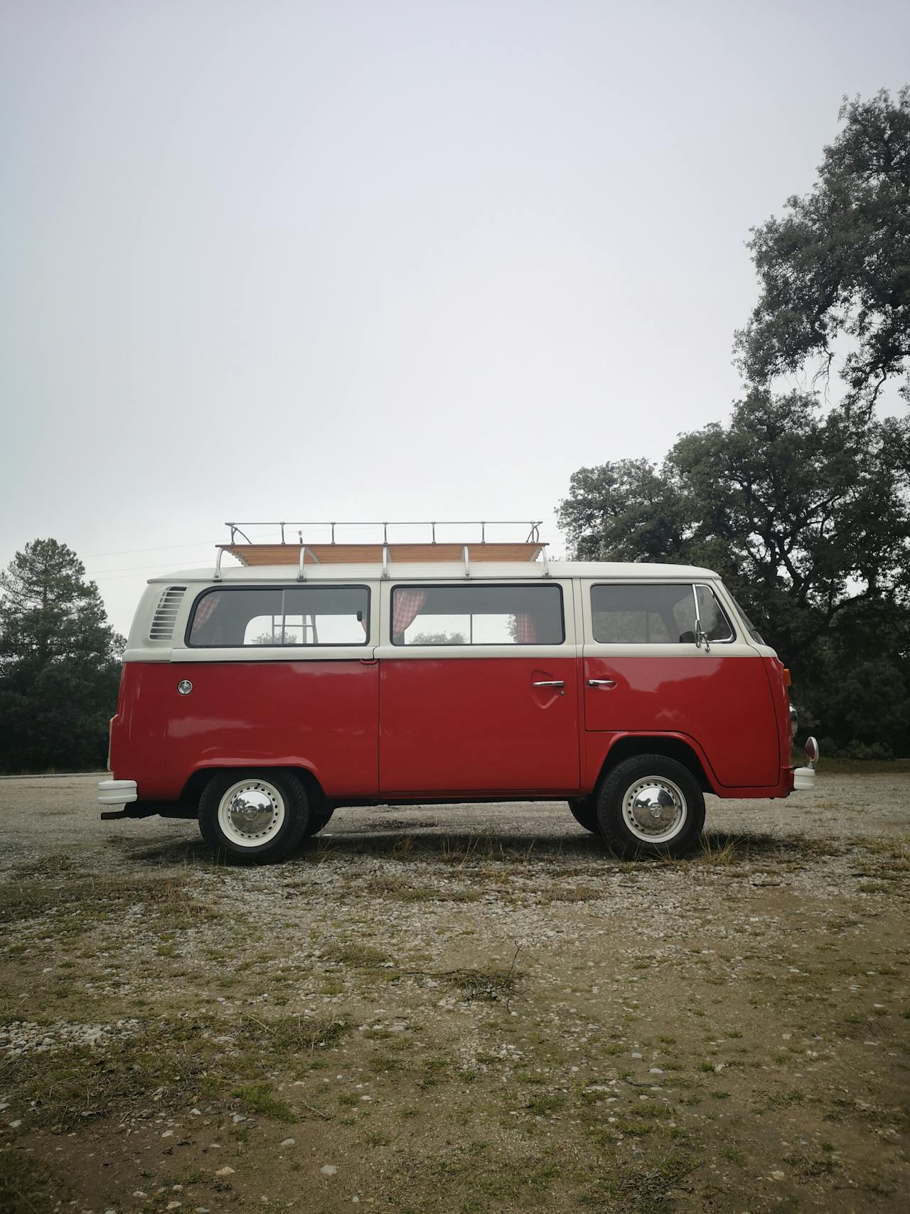 A red vintage minivan parked on a barren lawn | Source: Pexels