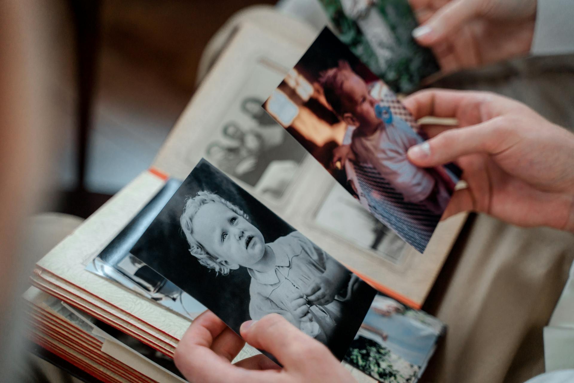 A woman looking at family photos in an album | Source: Pexels