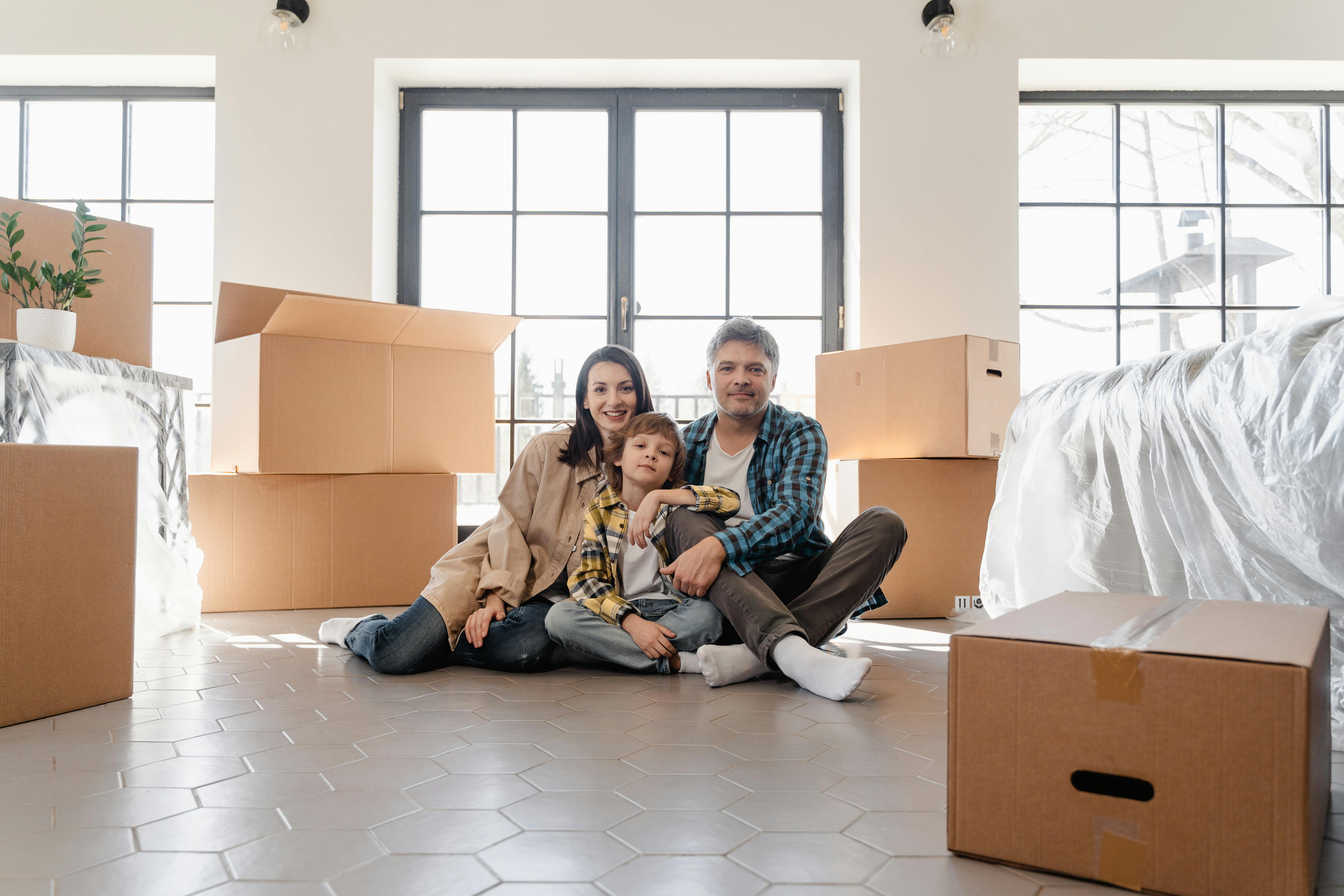 A couple and their child sitting on the floor | Source: Pexels
