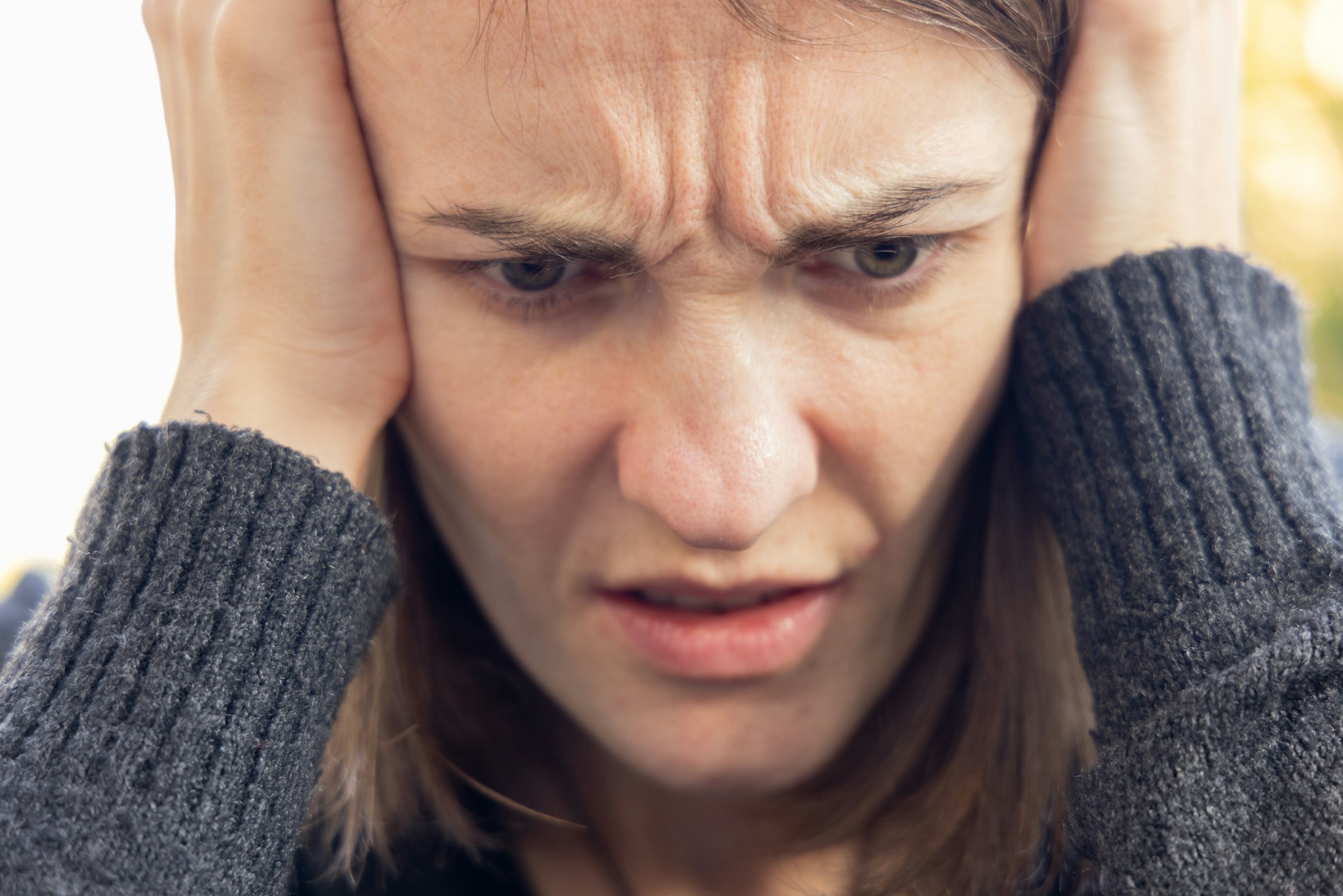 A frowning woman with her head in her hands | Source: Unsplash