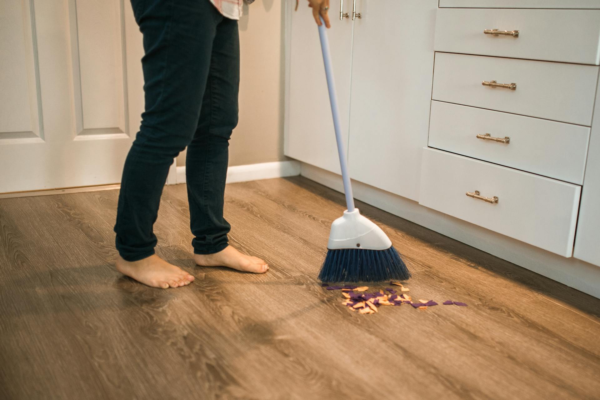 A woman sweeping the floor | Source: Pexels