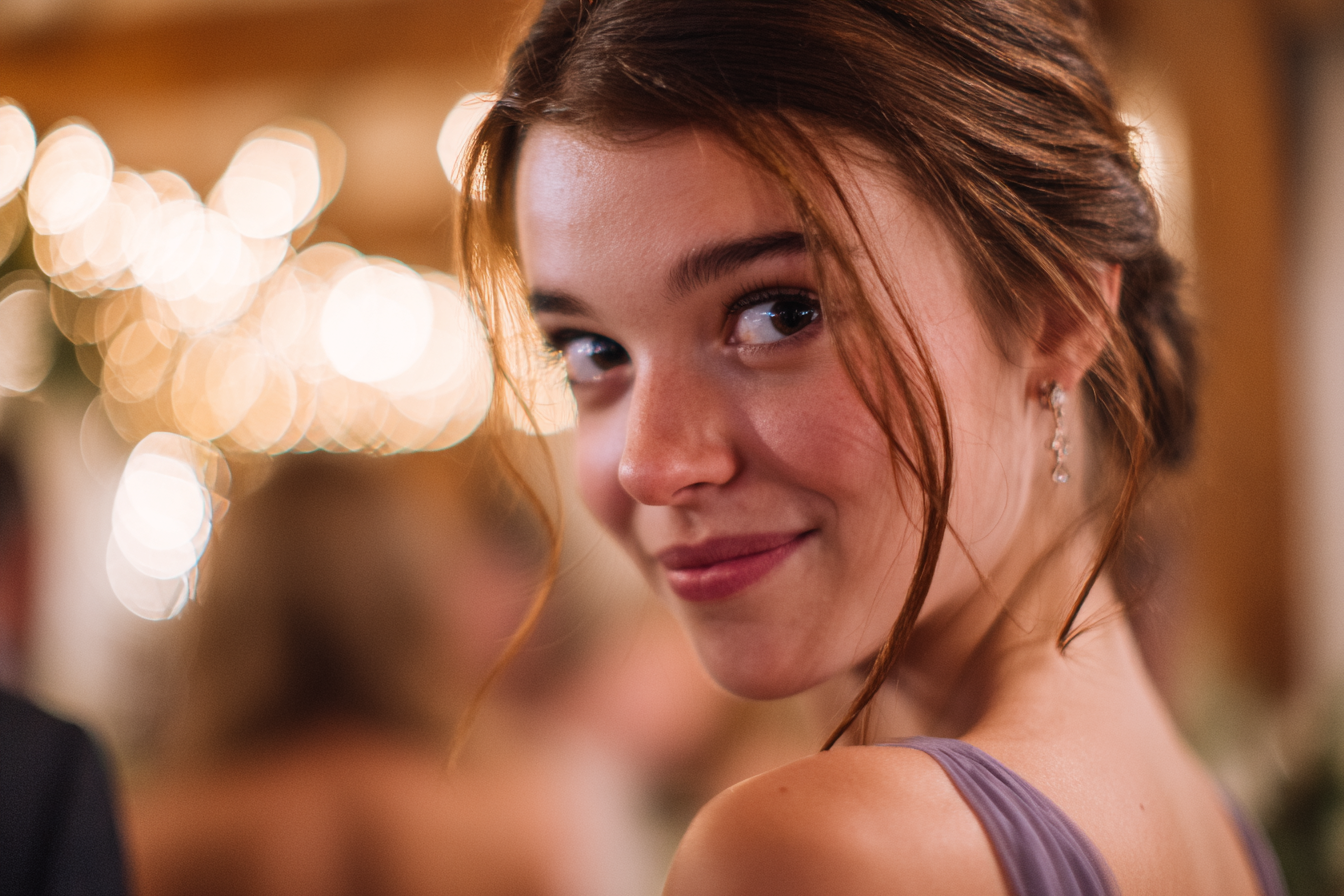 A young woman smiling mischievously | Source: Midjourney