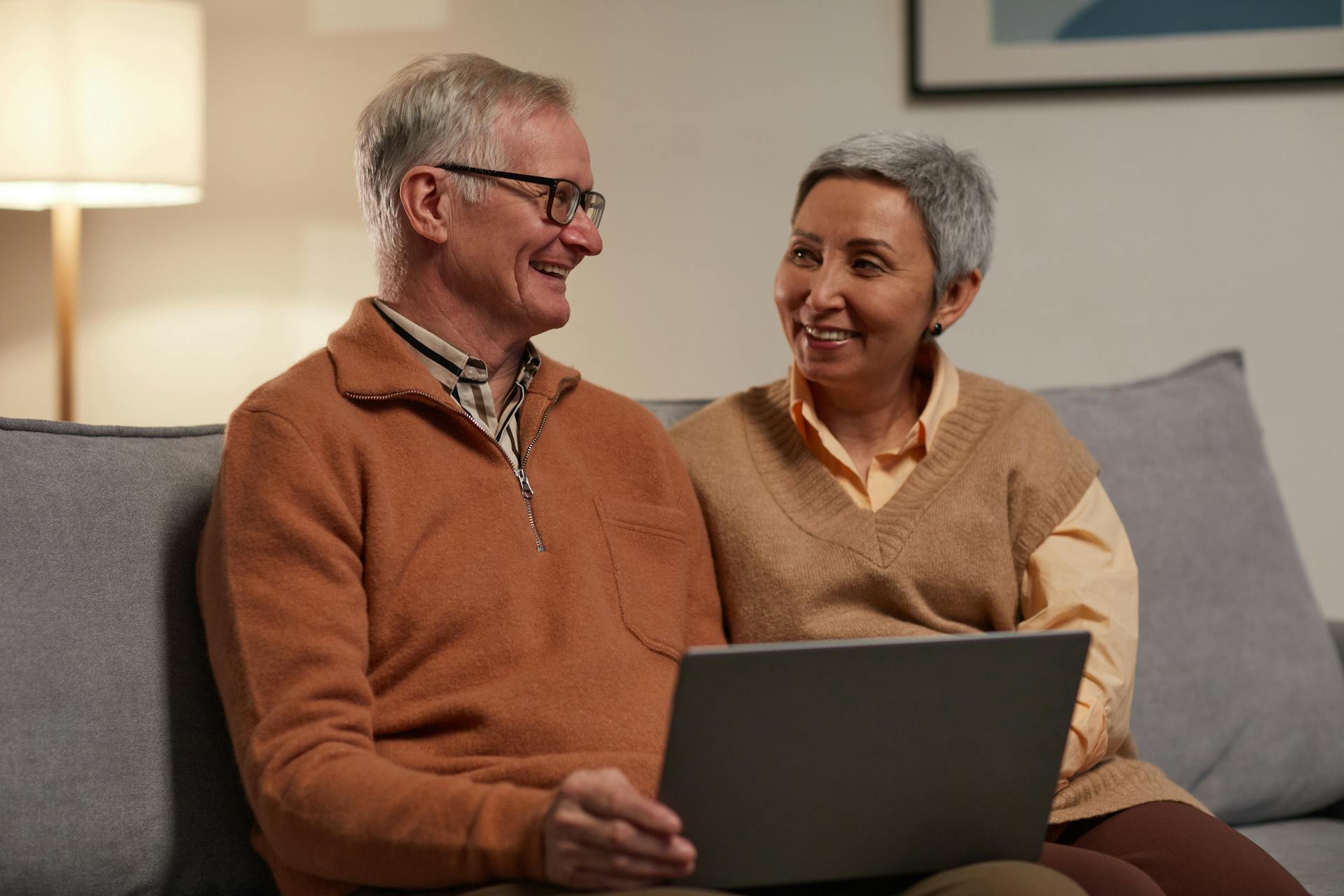A happy couple using a laptop | Source: Pexels