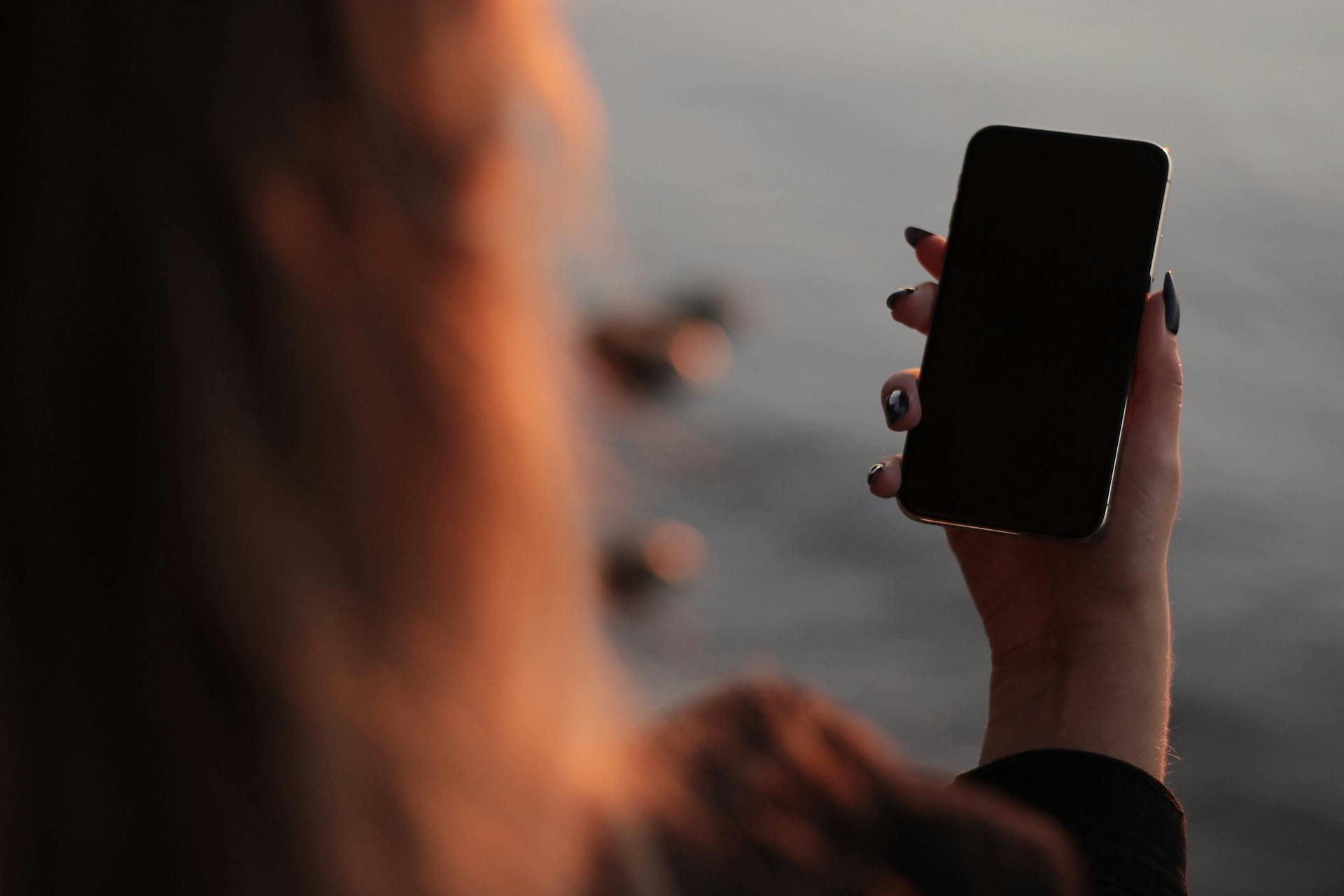 A woman holding a smartphone | Source: Pexels