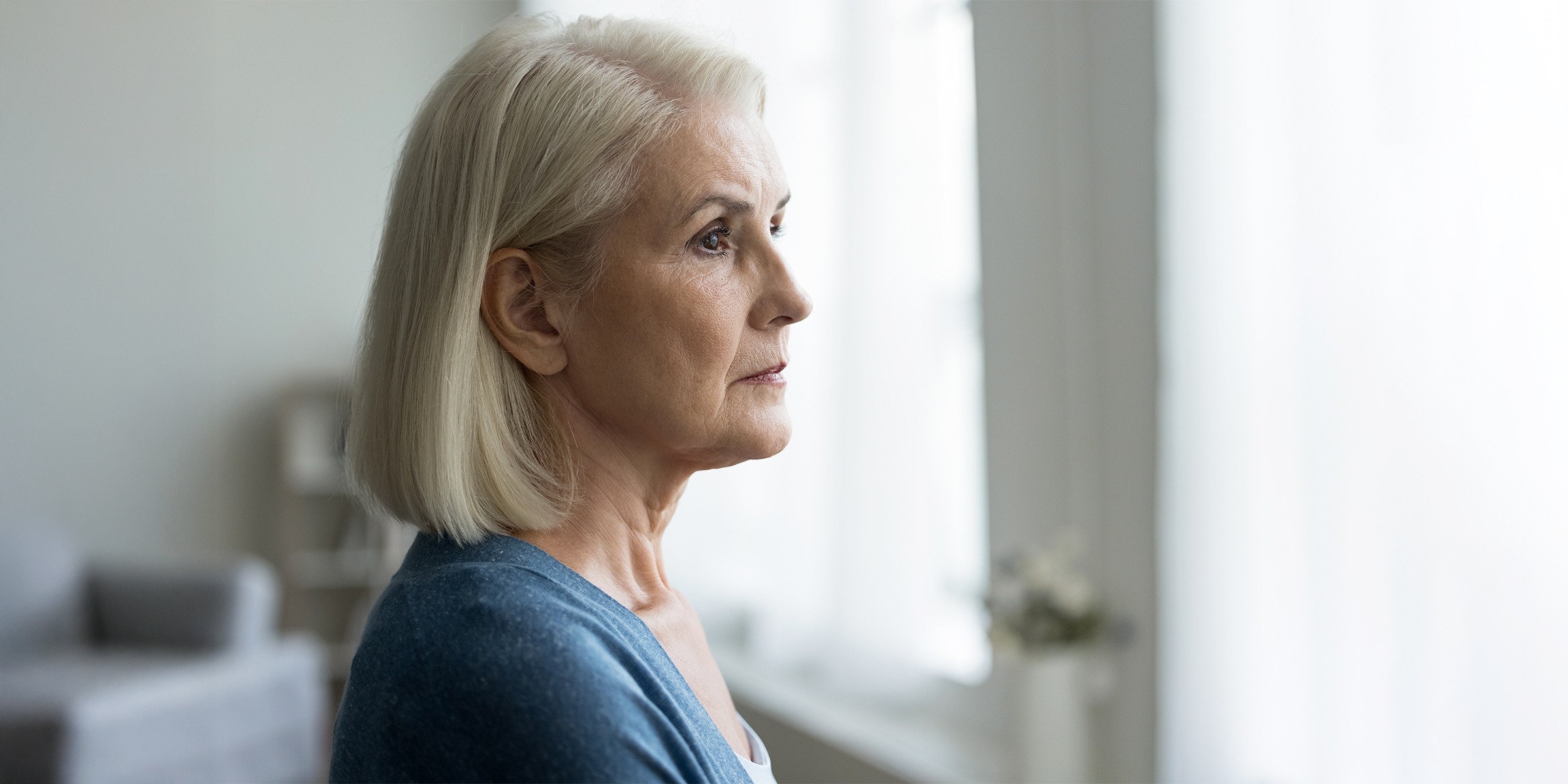 A tense woman staring out a window | Source: Shutterstock