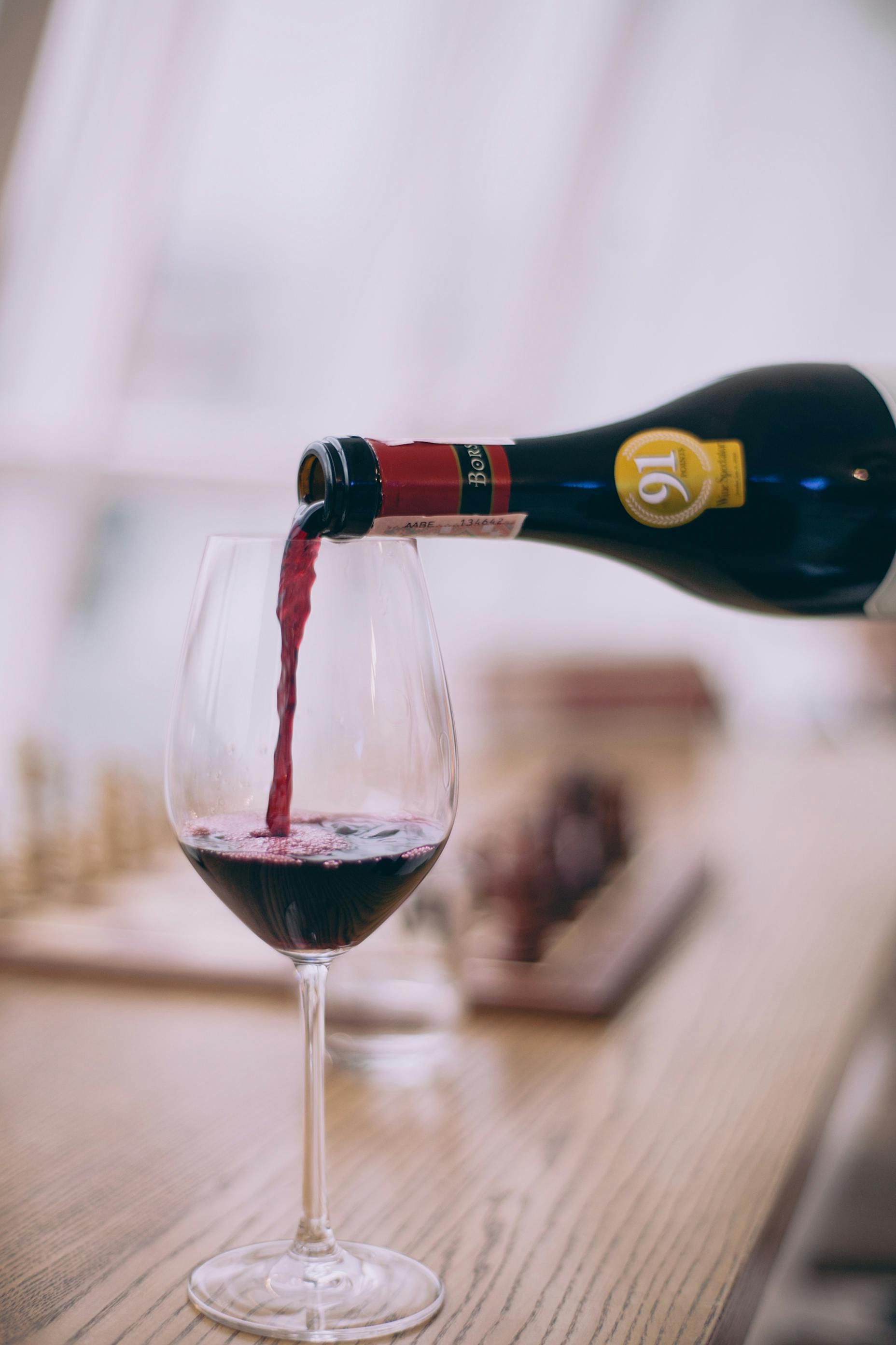 Vinho tinto sendo despejado em uma taça | Fonte: Pexels