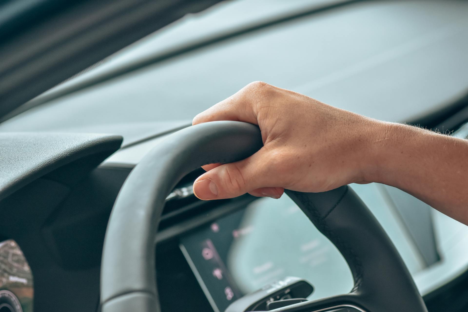 A person gripping the steering wheel | Source: Pexels