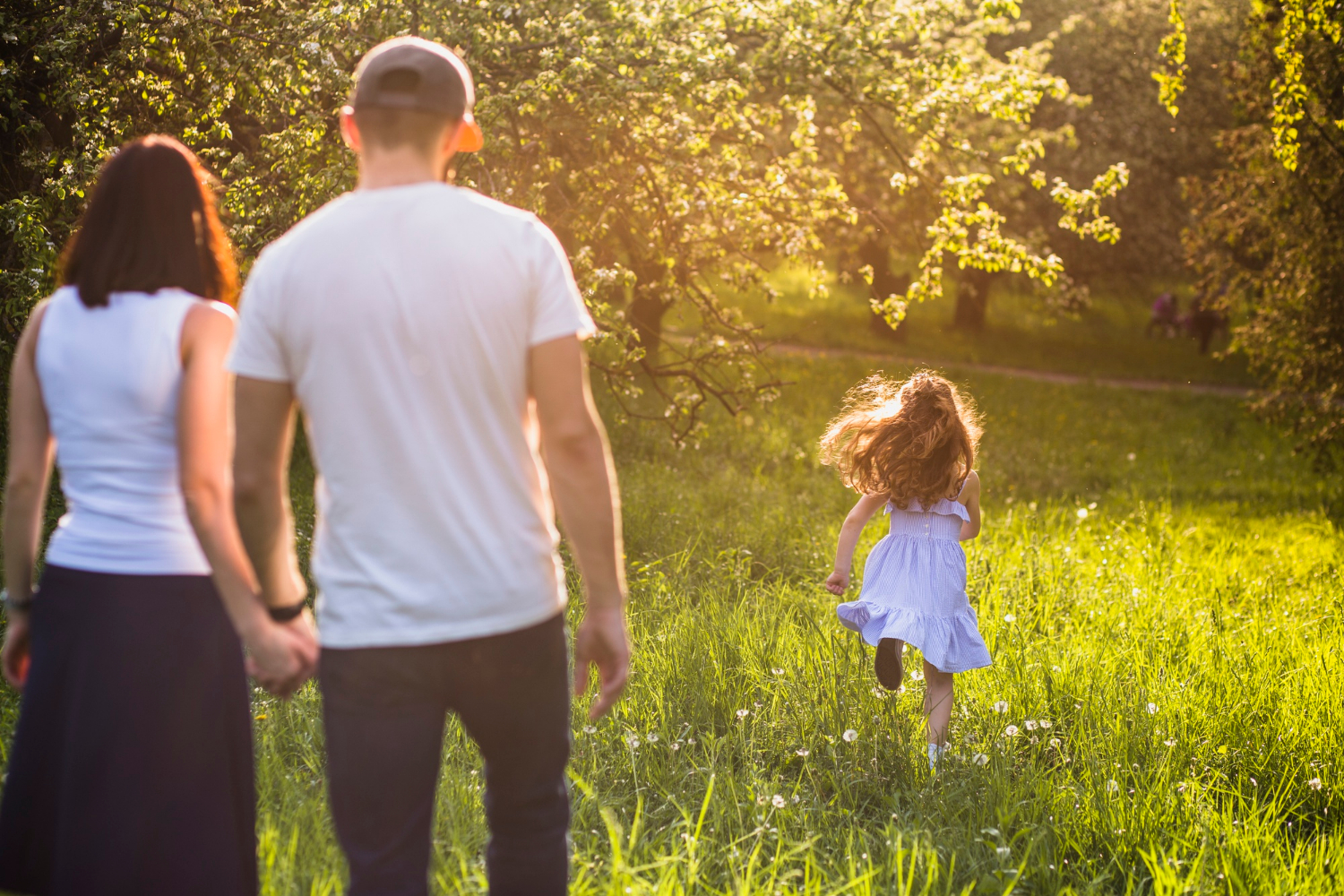 A couple watching their daughter running in a park | Source: Freepik