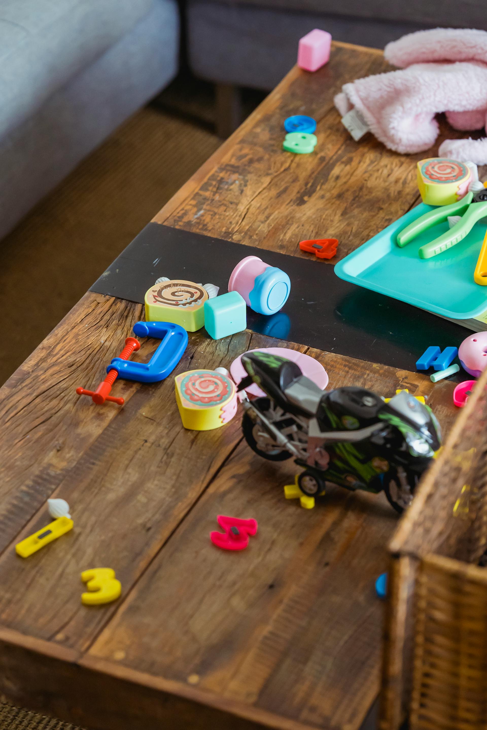 Scattered toys on a wooden table surface | Source: Pexels