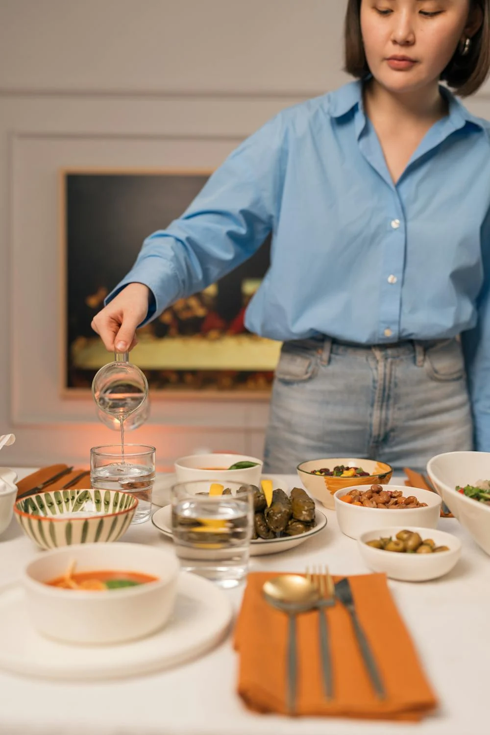 Une femme met la table ⏐ Source : Pexels