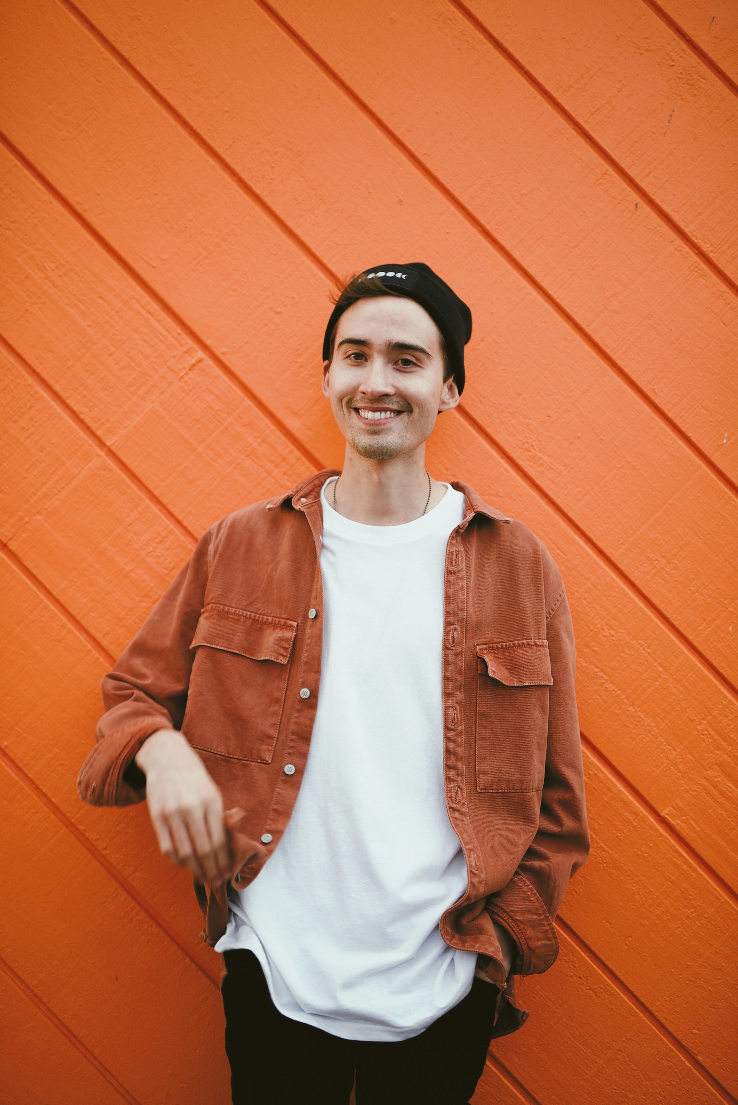 A man in a leather jacket standing beside a wall | Source: Unsplash