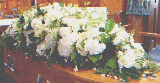 A coffin with flower on top of it | Source: Shutterstock