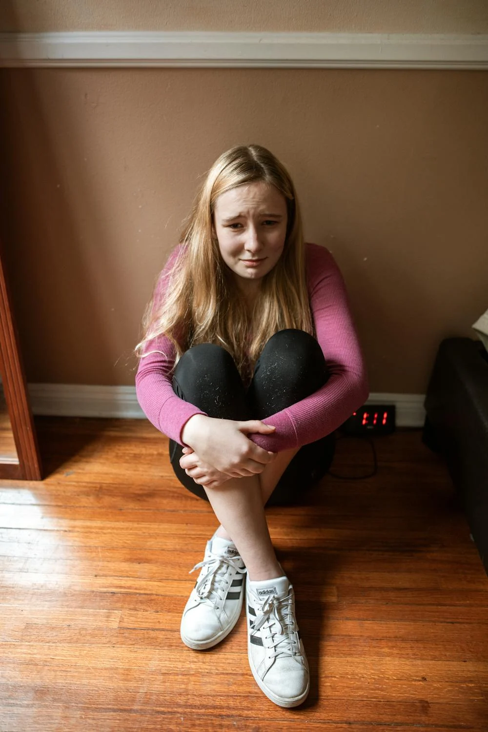 A crying girl sitting on the floor | Source: Pexels