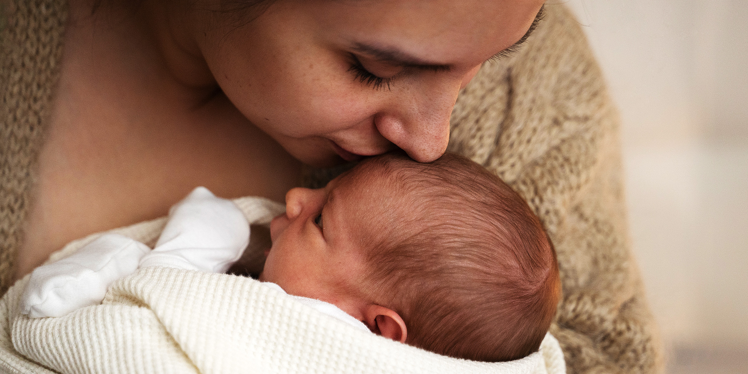 A woman kissing her baby | Source: Freepik