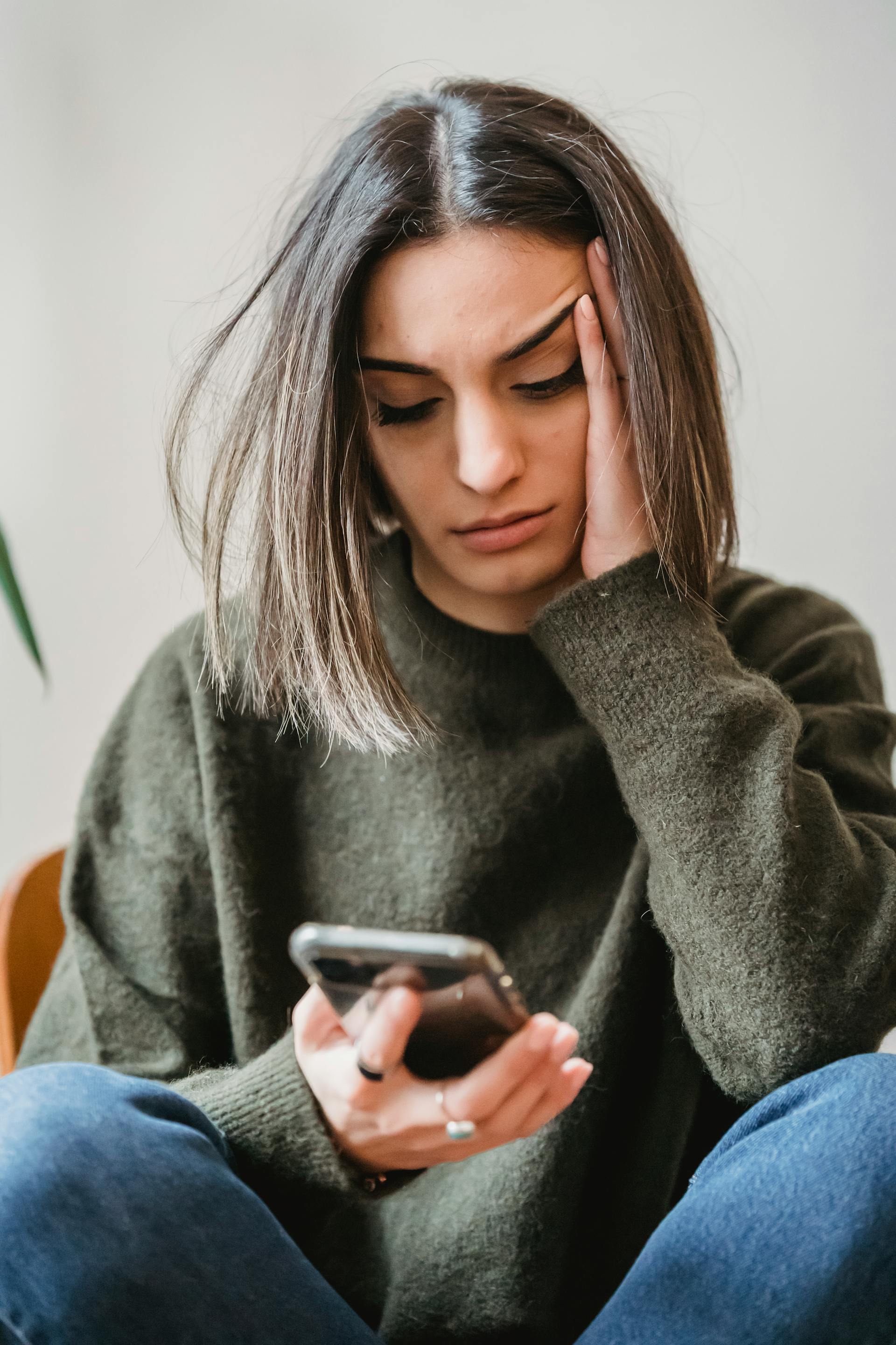 A depressed woman looking at her phone | Source: Pexels