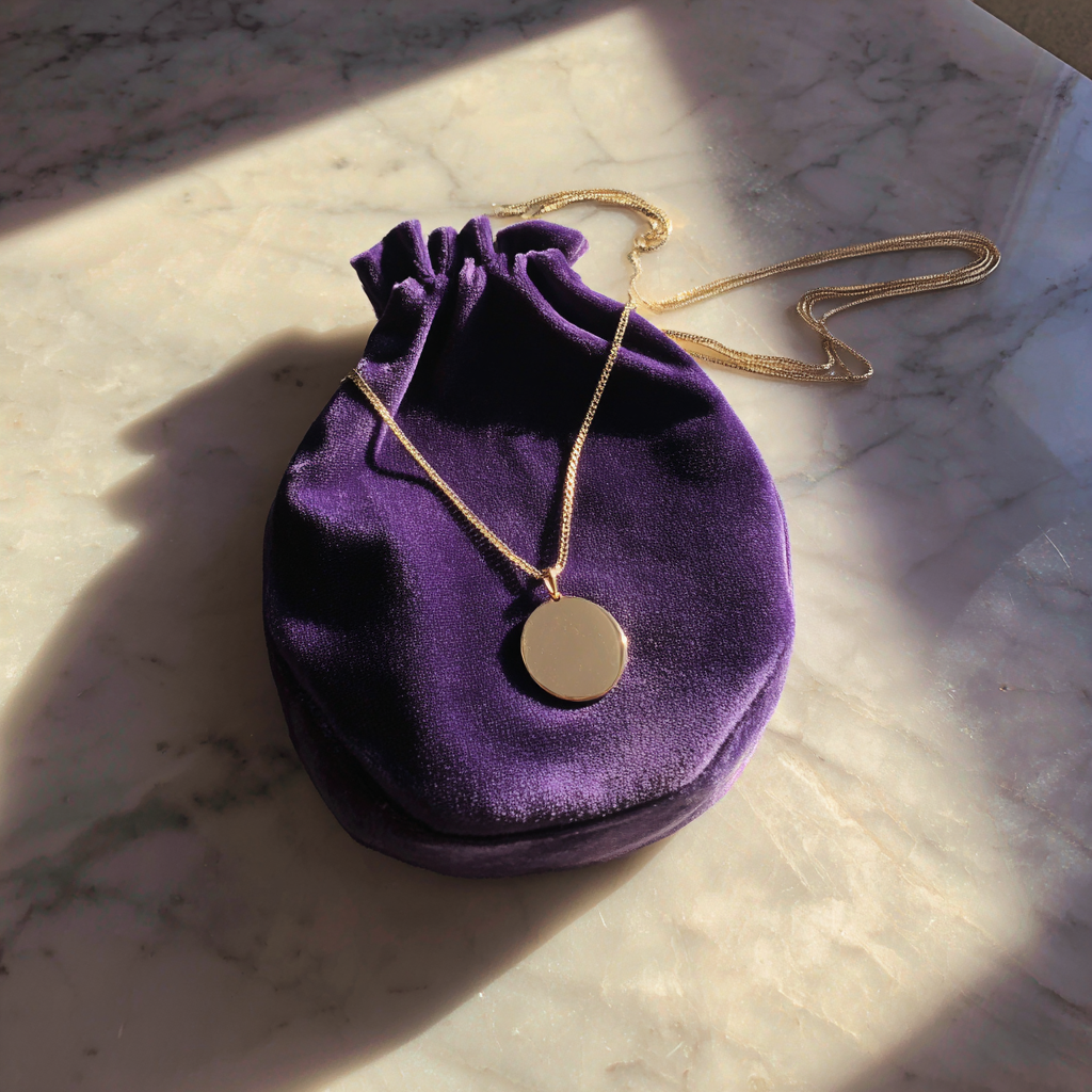 A purple velvet pouch with a gold necklace on it | Source: Midjourney