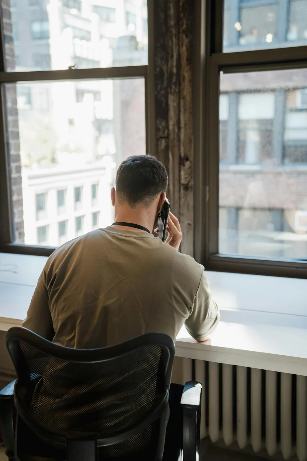 A man talking on his phone in his living room | Source: Pexels