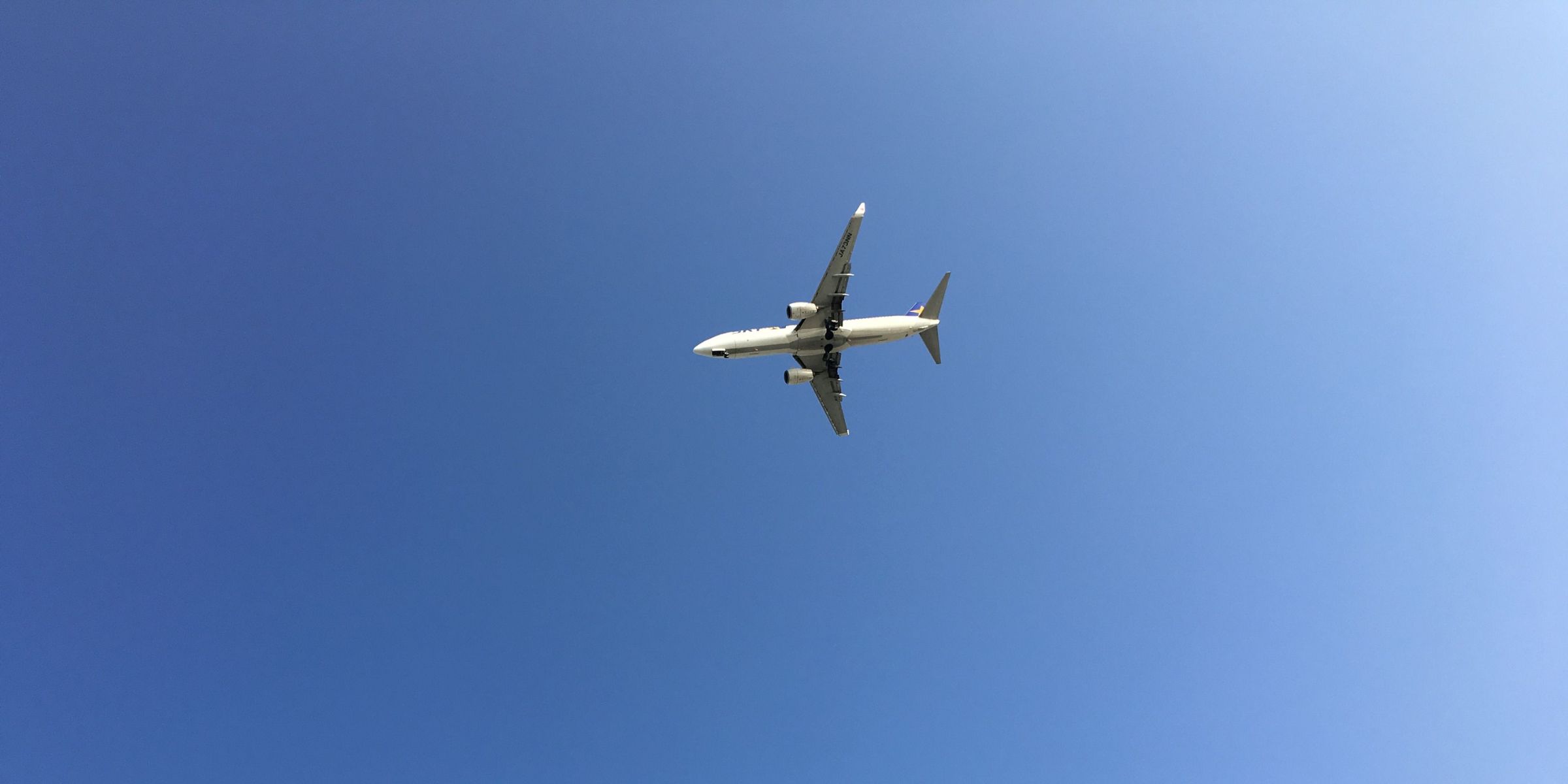A commercial airplane flying through a clear blue sky | Source: Pexels