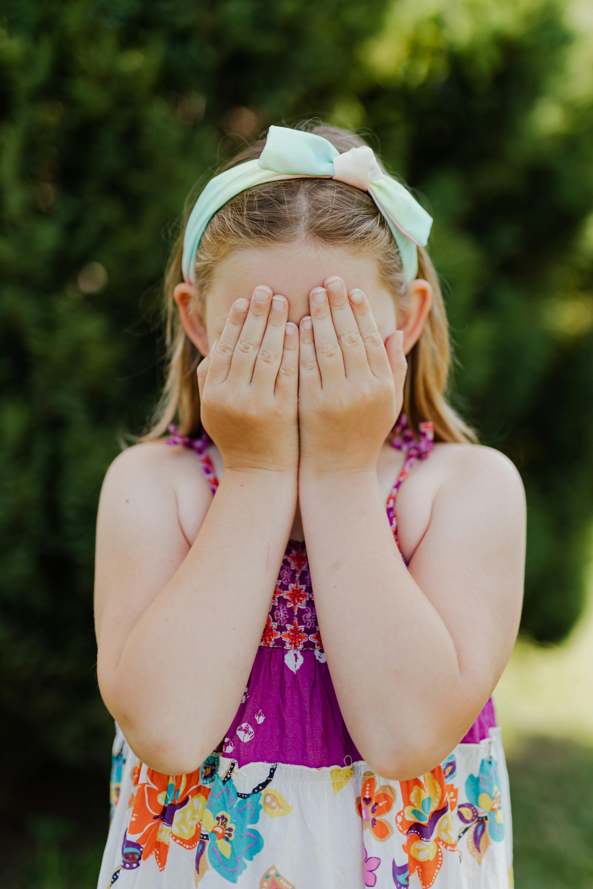 A little girl covering her face with her hands | Source: Pexels