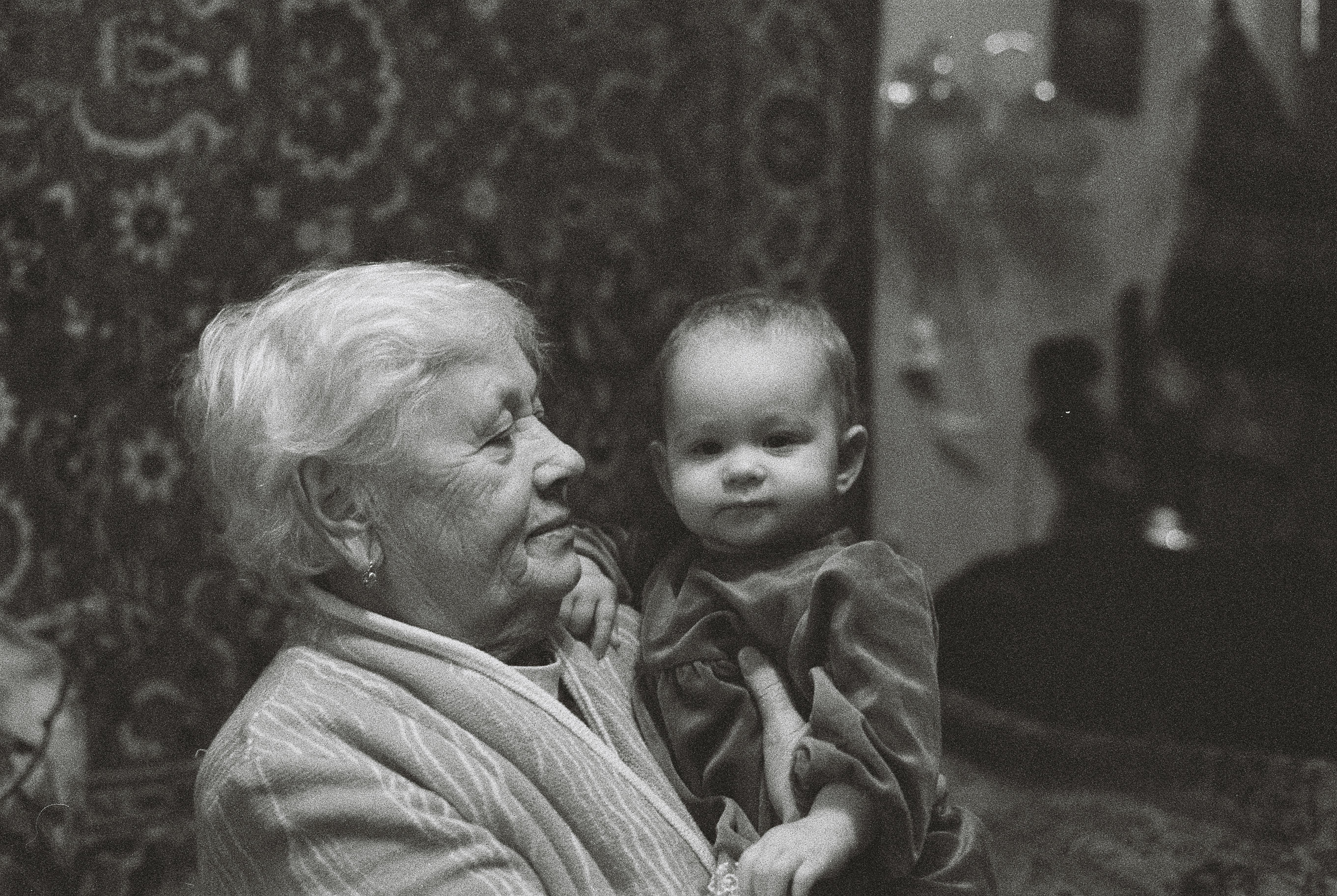 An elderly woman carrying a baby | Source: Pexels